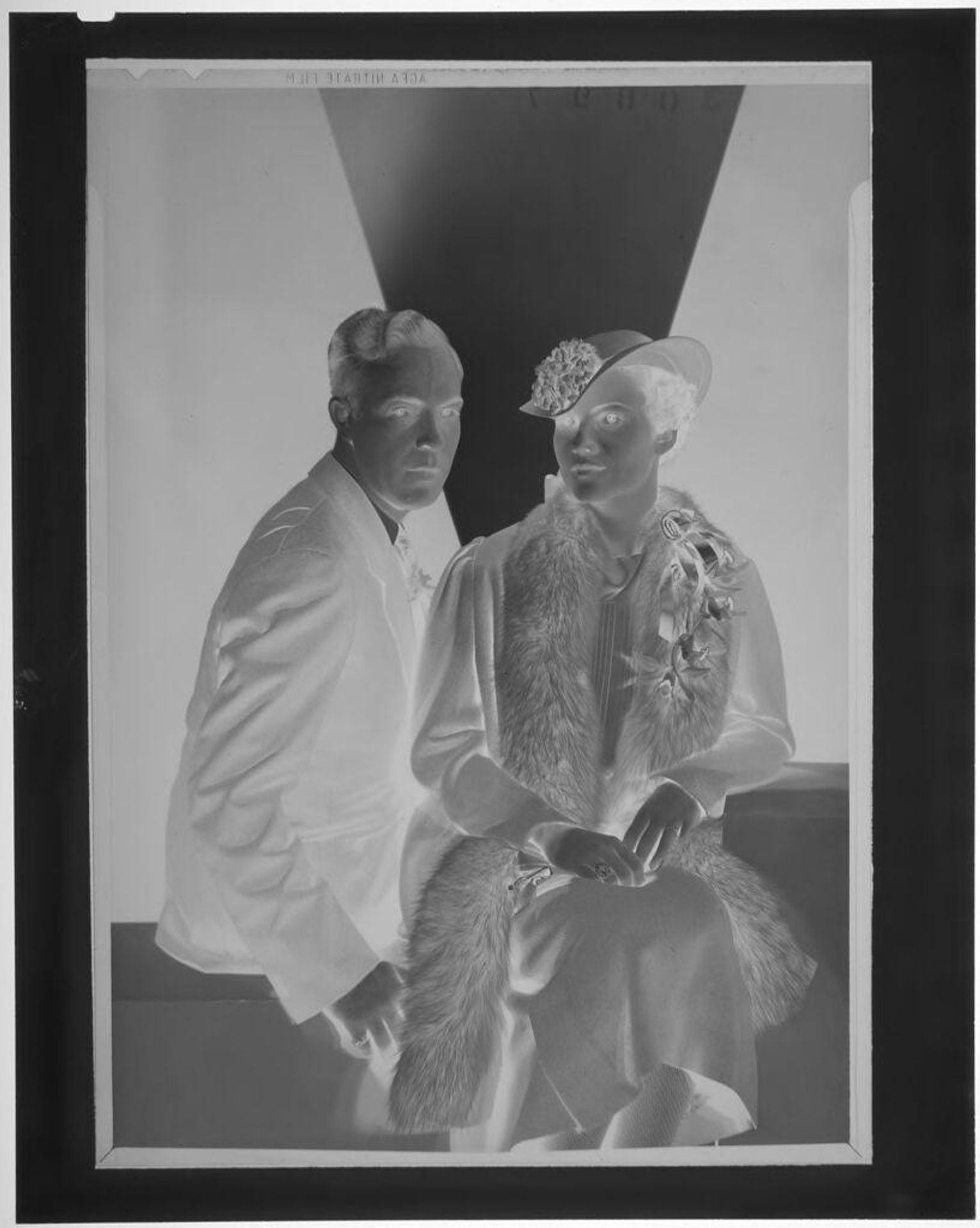 Untitled (studio portrait of couple with woman wearing hat with flower and fur-lined coat) by Martin Schweig