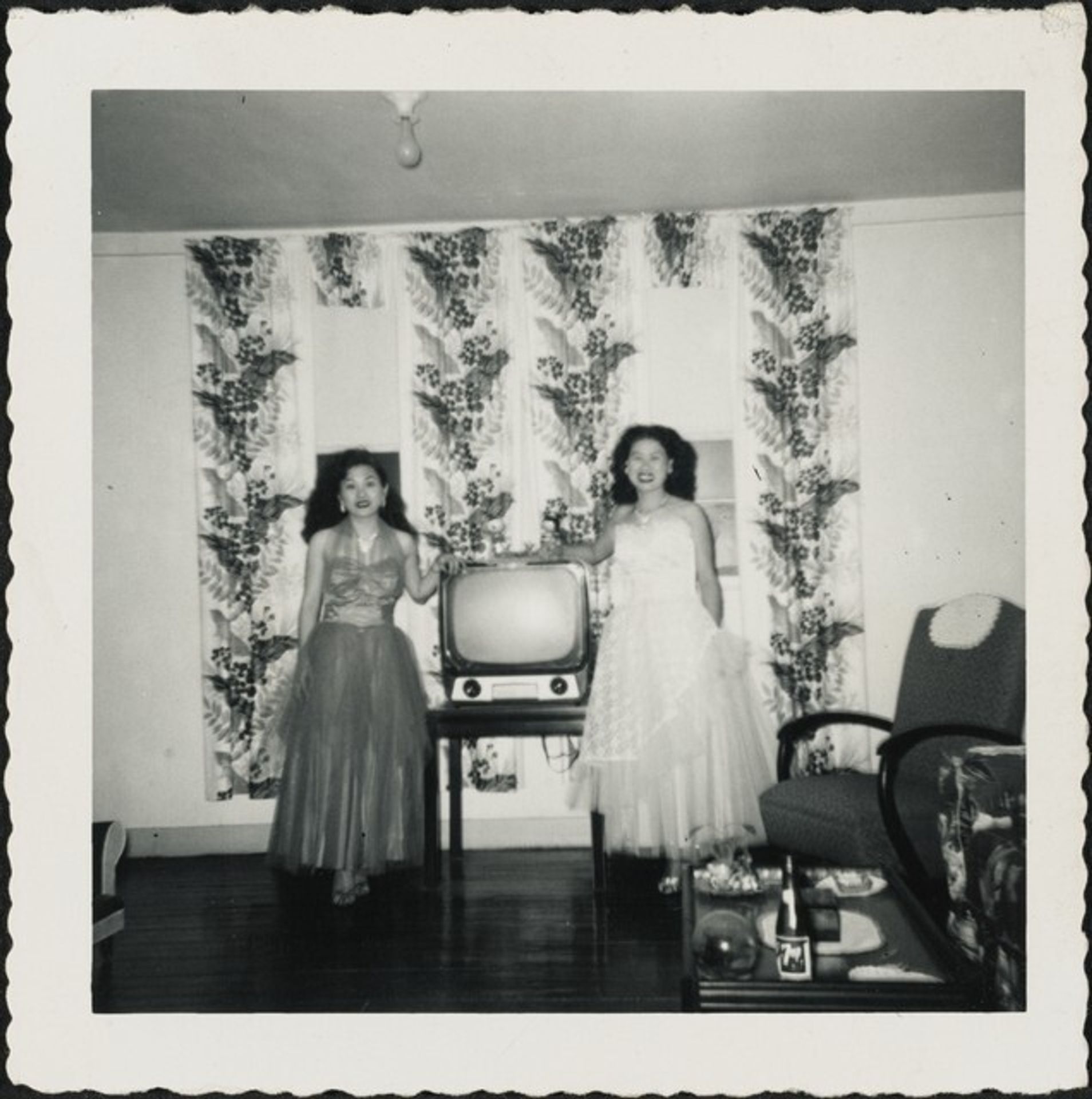 Untitled (Two women in gowns in front of television) by Anonymous