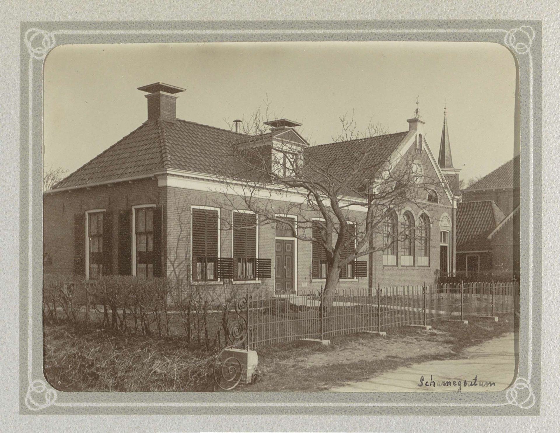Huis en een schoolgebouw in Scharnegoutum, op de achtergrond een kerktoren by Folkert Idzes de Jong