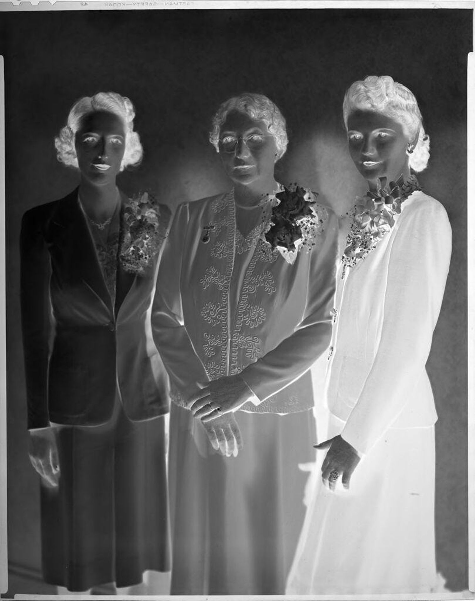 Untitled (portrait of three women standing, dressed in suits, corsages) by Harris & Ewing