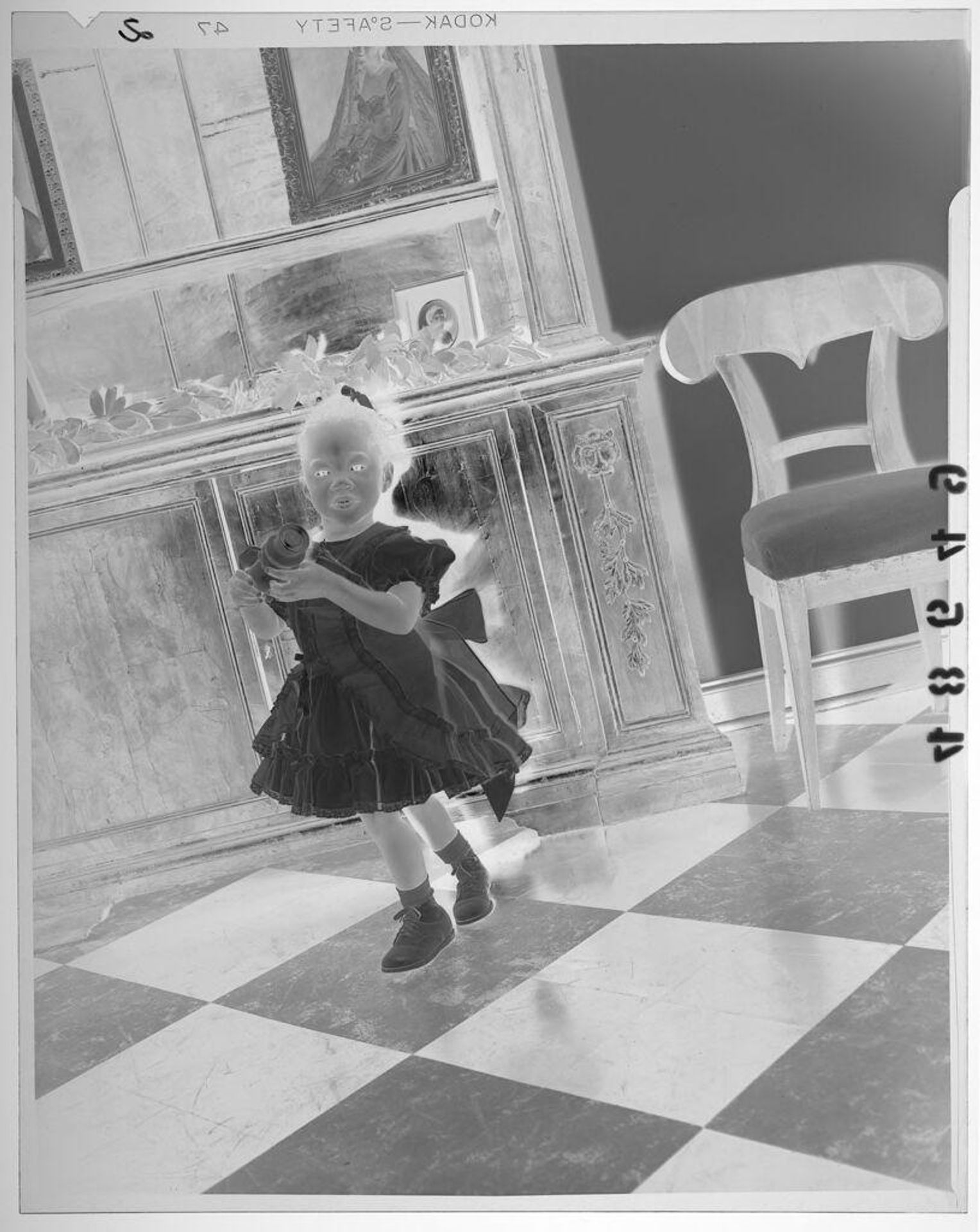 Untitled (young girl in dress posed holding toy in fancy room) by Martin Schweig