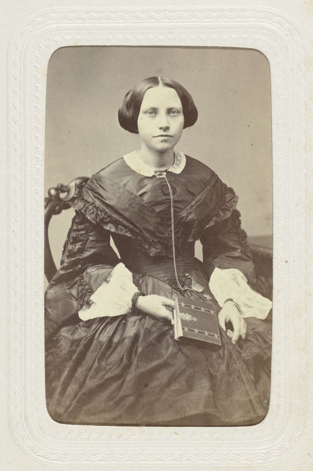 Studioportret van een jonge vrouw gekleed in een bolle zwarte jurk by Willem Tinker