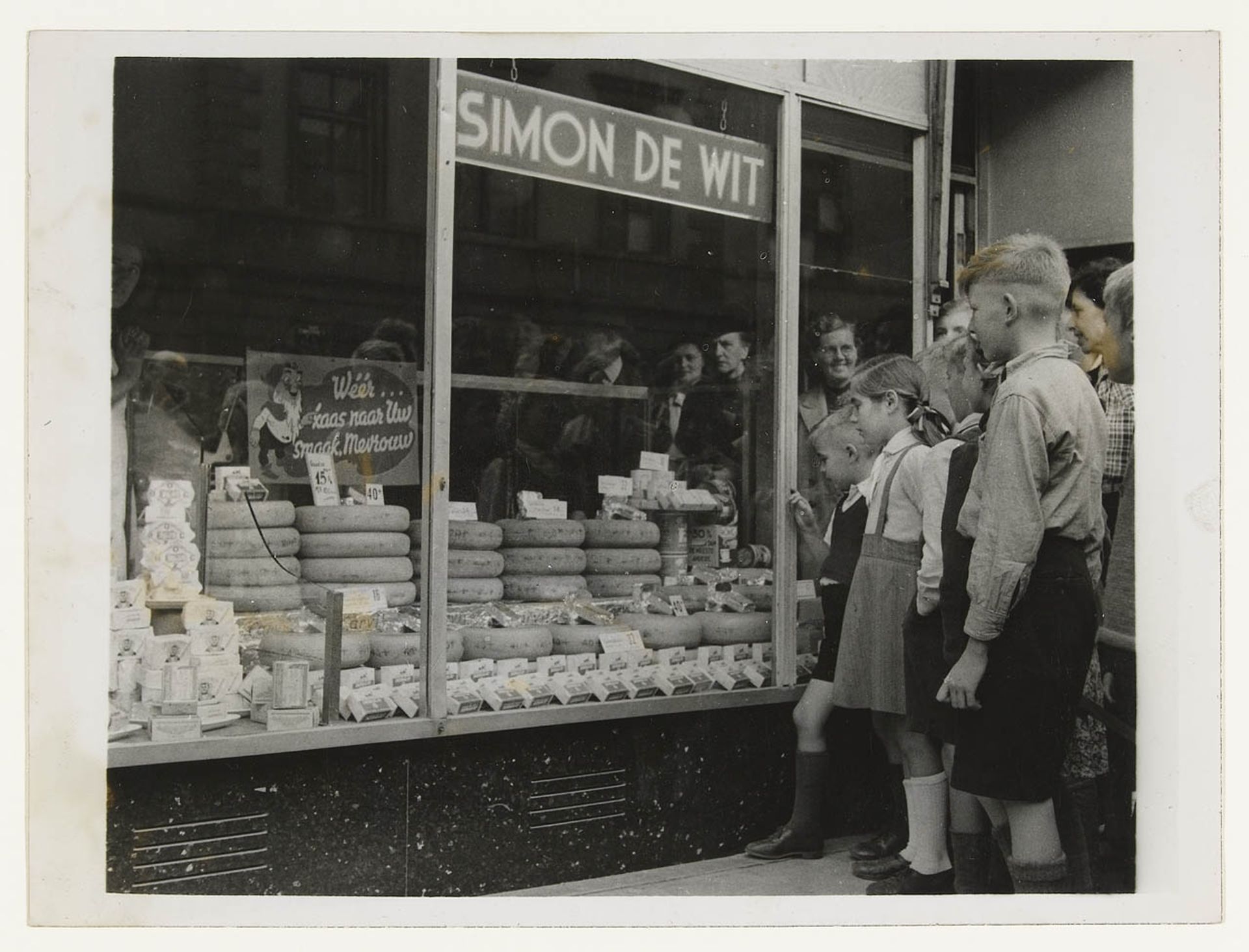 Mensen verlekkeren zich aan de etalage van kaaswinkel Simon de Wit by Keystone Press Agency