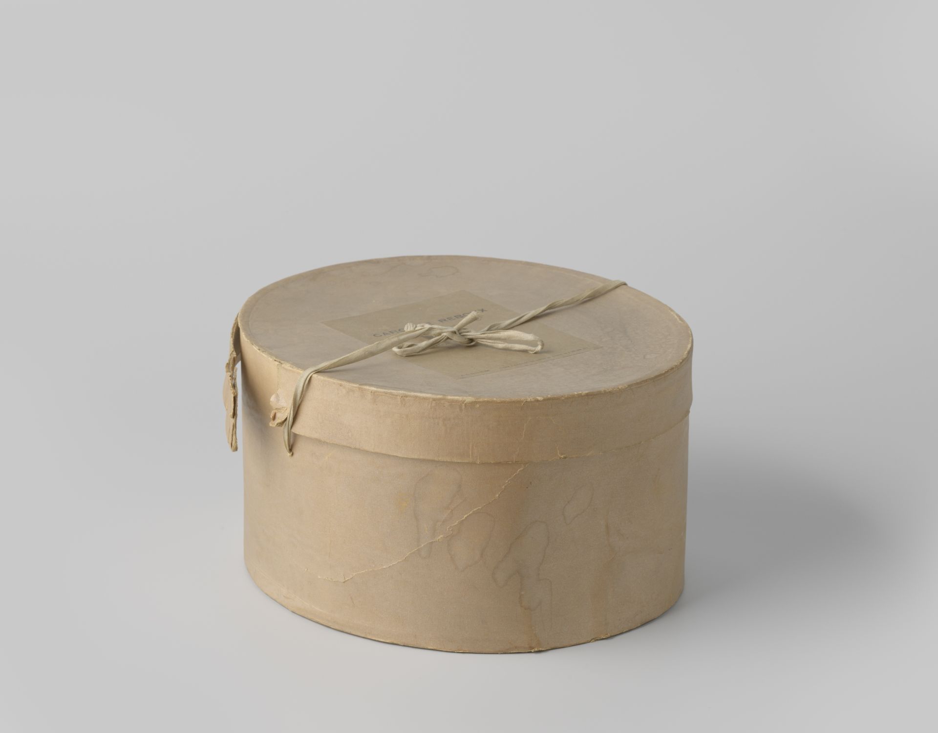 Ovale hoedendoos van karton, bekleed met beige ripspapier by Caroline Reboux
