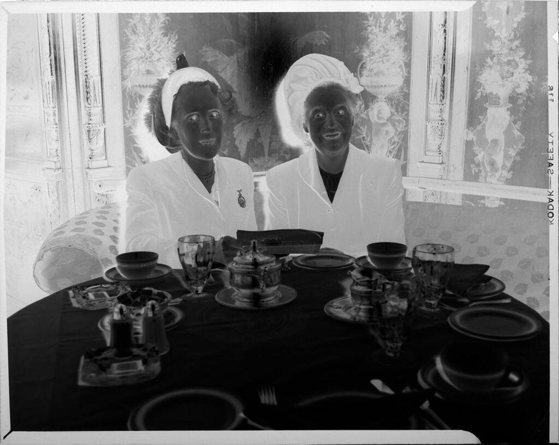 Untitled (two women sitting at table) by Peter James Studio