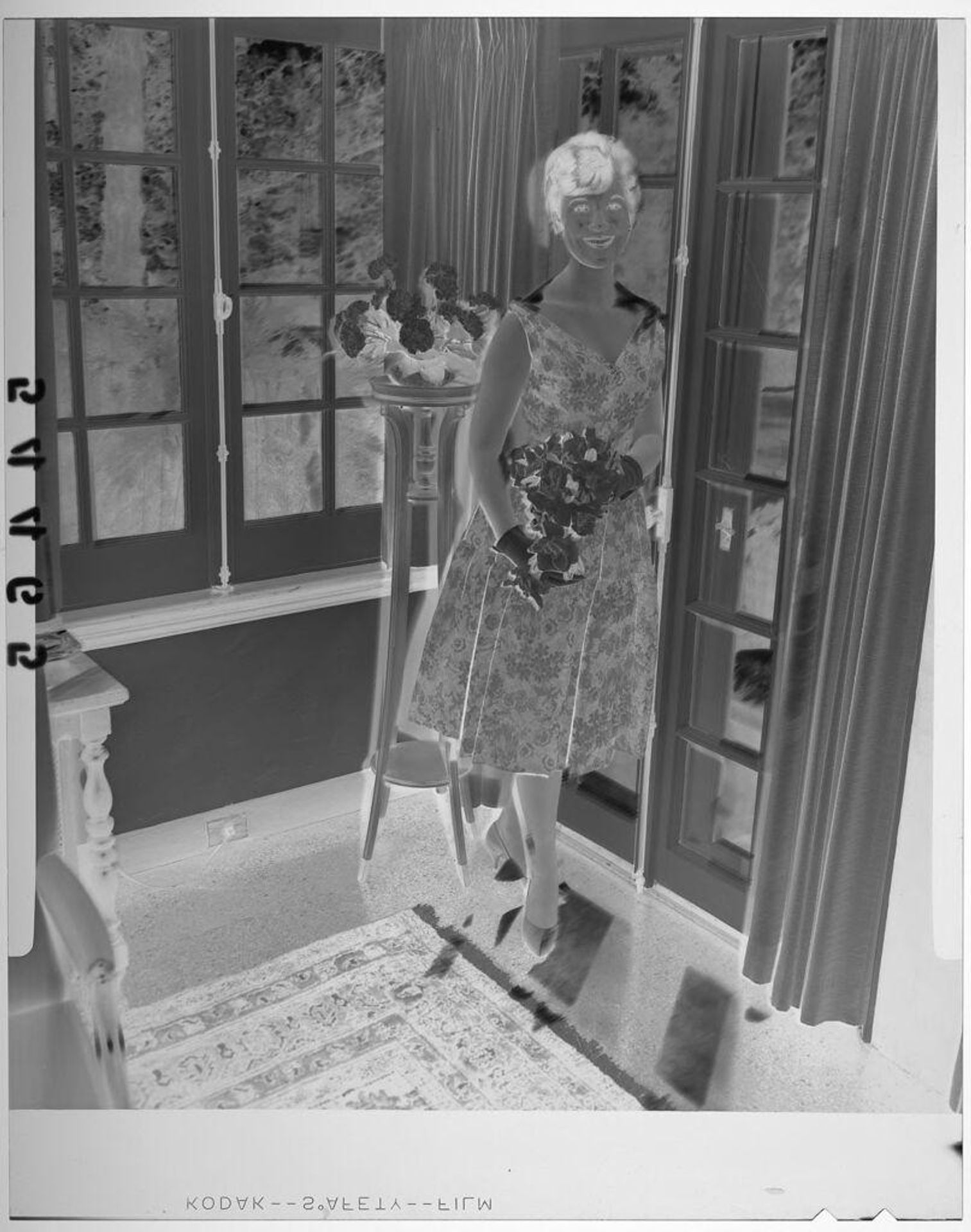 Untitled (young woman posing with bouquet by windows at debutante party) by Martin Schweig
