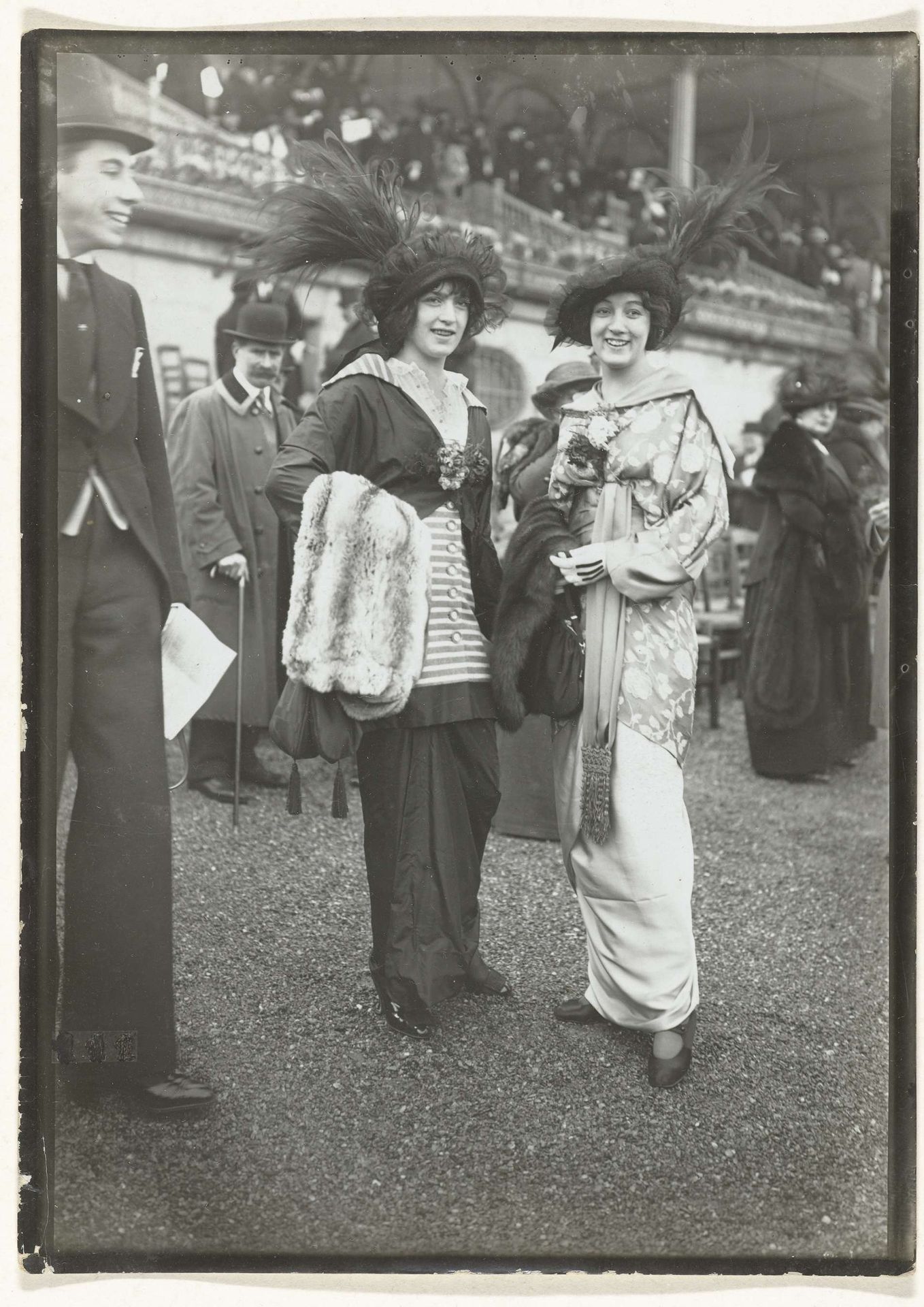Twee vrouwen tussen publiek tijdens paardenraces, mogelijk bij het Hippodrome de Longchamp in het Bois de Boulogne by Frères Séeberger