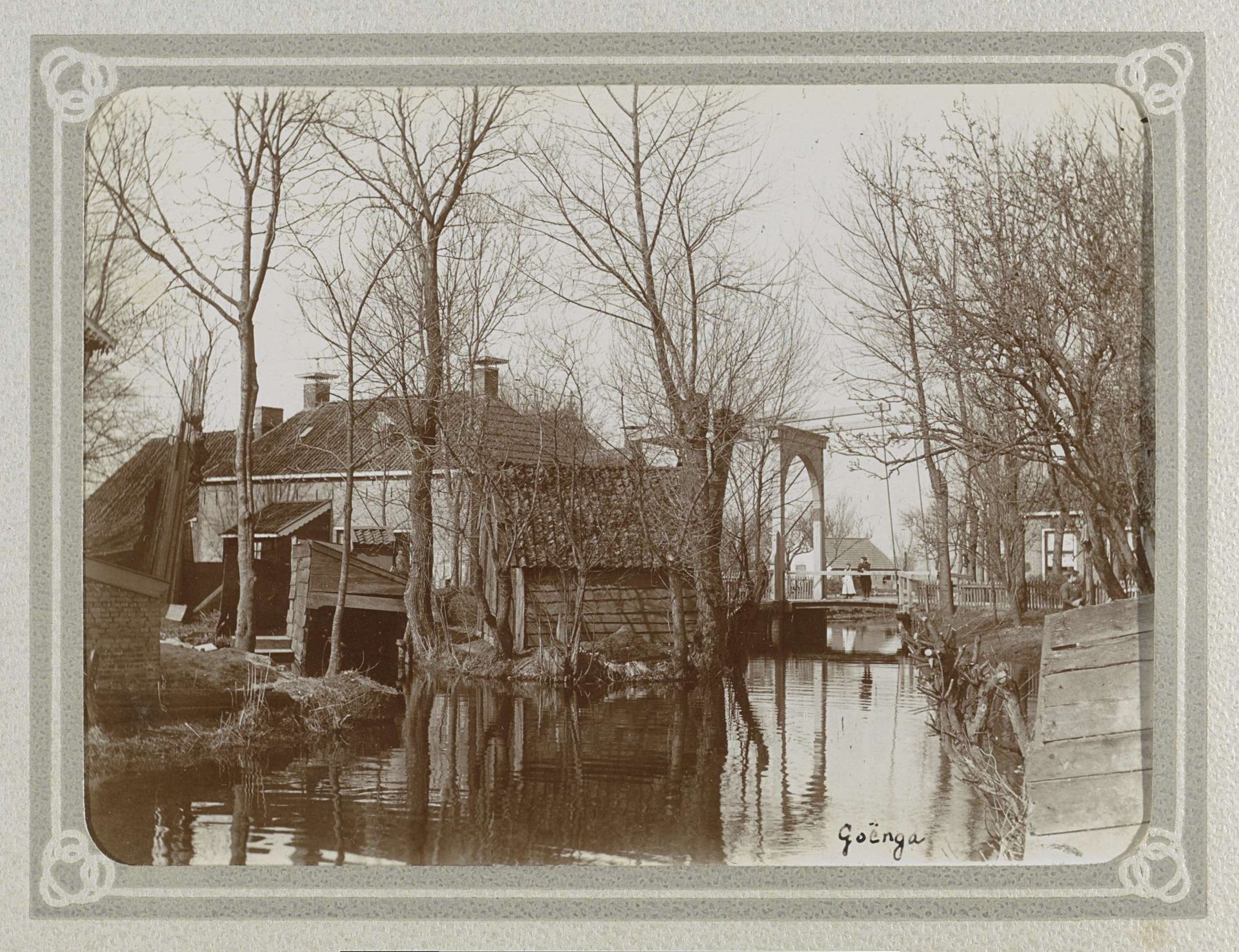 Huizen, schuren, een brug met twee kinderen en een sloot in Goënga by Folkert Idzes de Jong