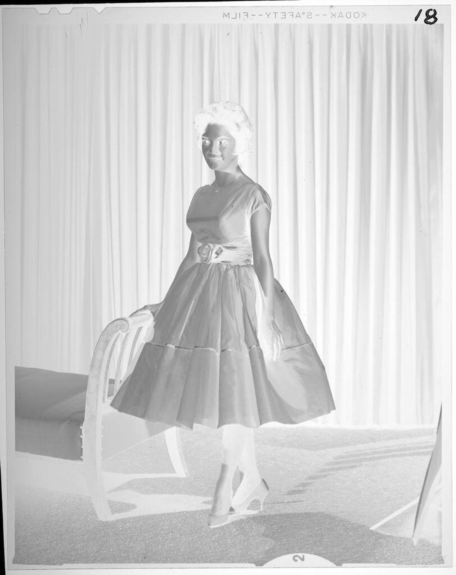 Untitled (portrait of woman in fancy fress standing in front of curtains) by Lucian and Mary Brown