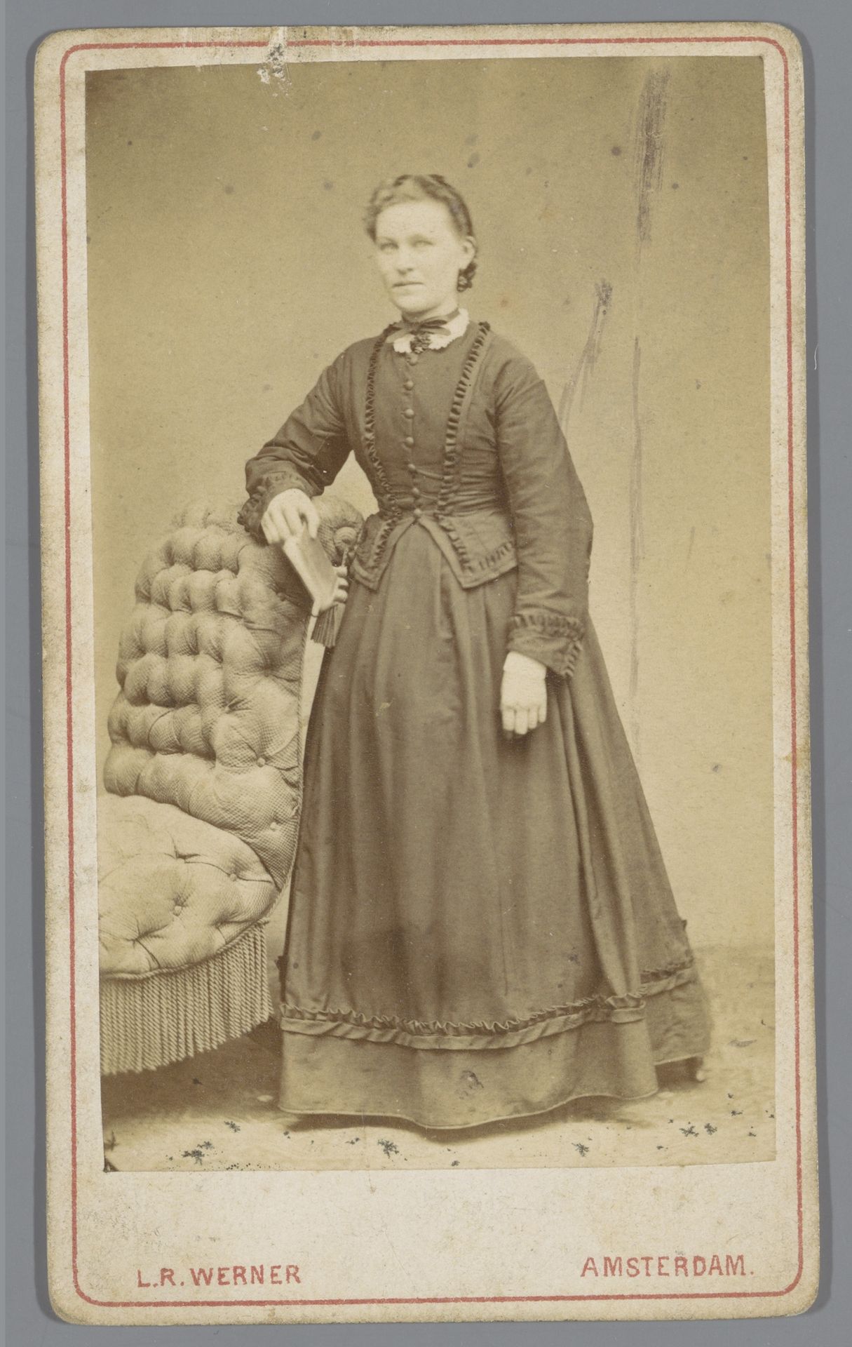 Portret van een onbekende vrouw met boek naast een fauteuil by Louis Robert Werner