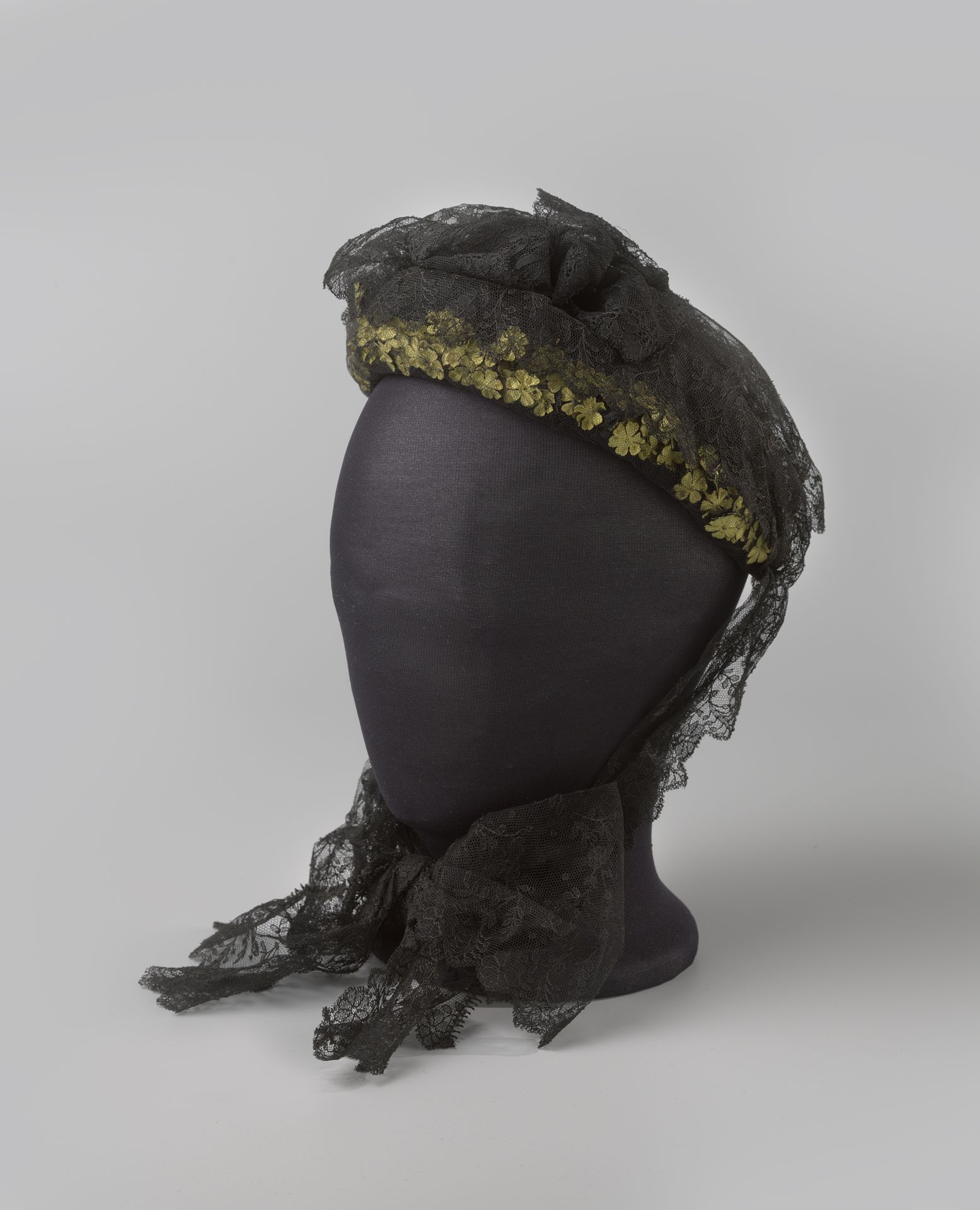 Capote van imitatie Chantilly kant, versierd met gele stoffen bloemen by M.S. van der Voort