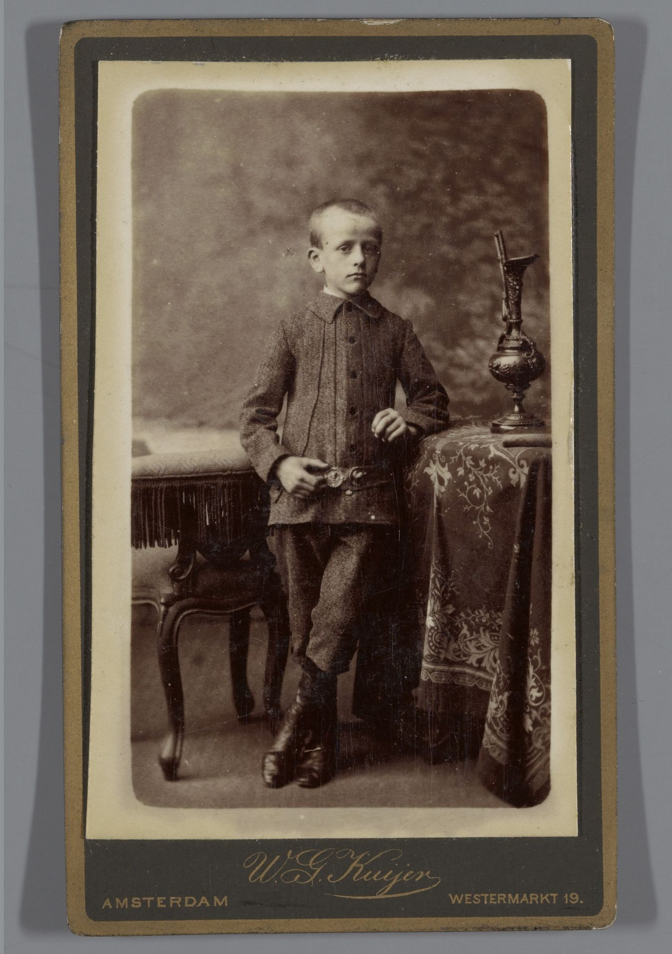 Portret van een onbekende jongen bij meubels by Willem Gerhardus Kuijer