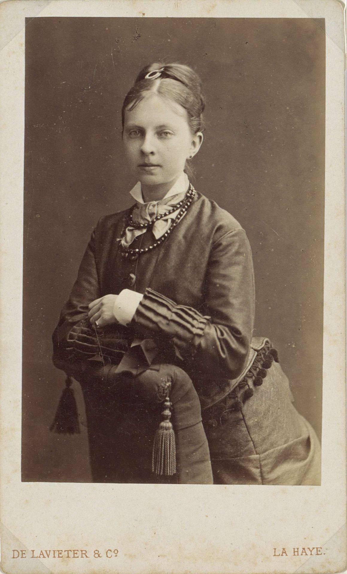 Portret van een vrouw, leunend op een fauteuil by De Lavieter & Co.