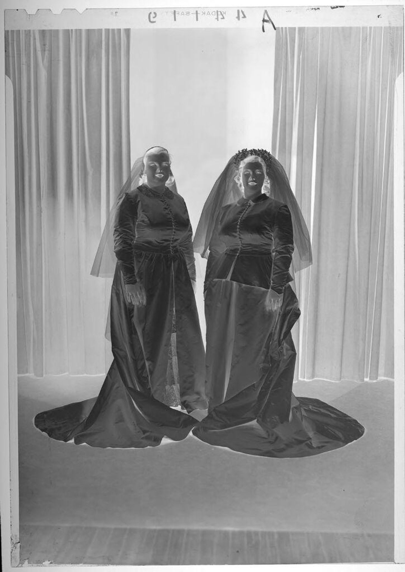 Untitled (studio portrait of two brides wearing dresses and veils) by Martin Schweig