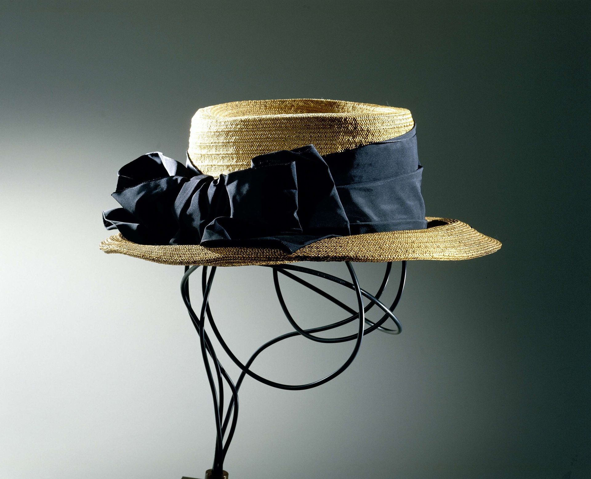 Hoed van gevlochten bandstro met rechte bol en brede, afhangende rand, versierd met gestrikt lint van zwart grosgrain by Gérard Albouy