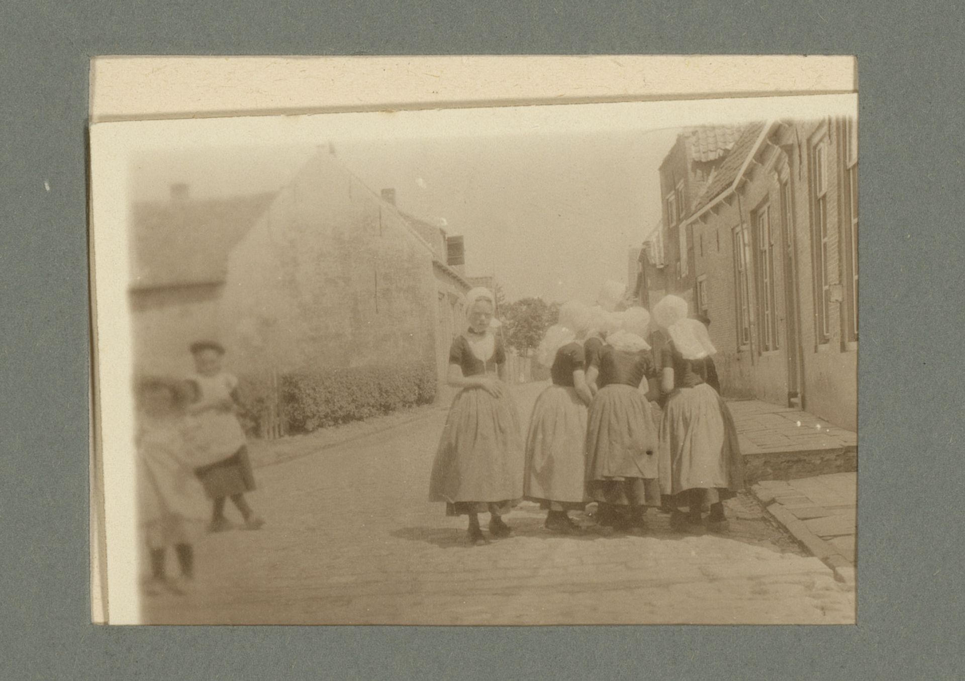 Meisjes in klederdracht op straat by G. Hidderley