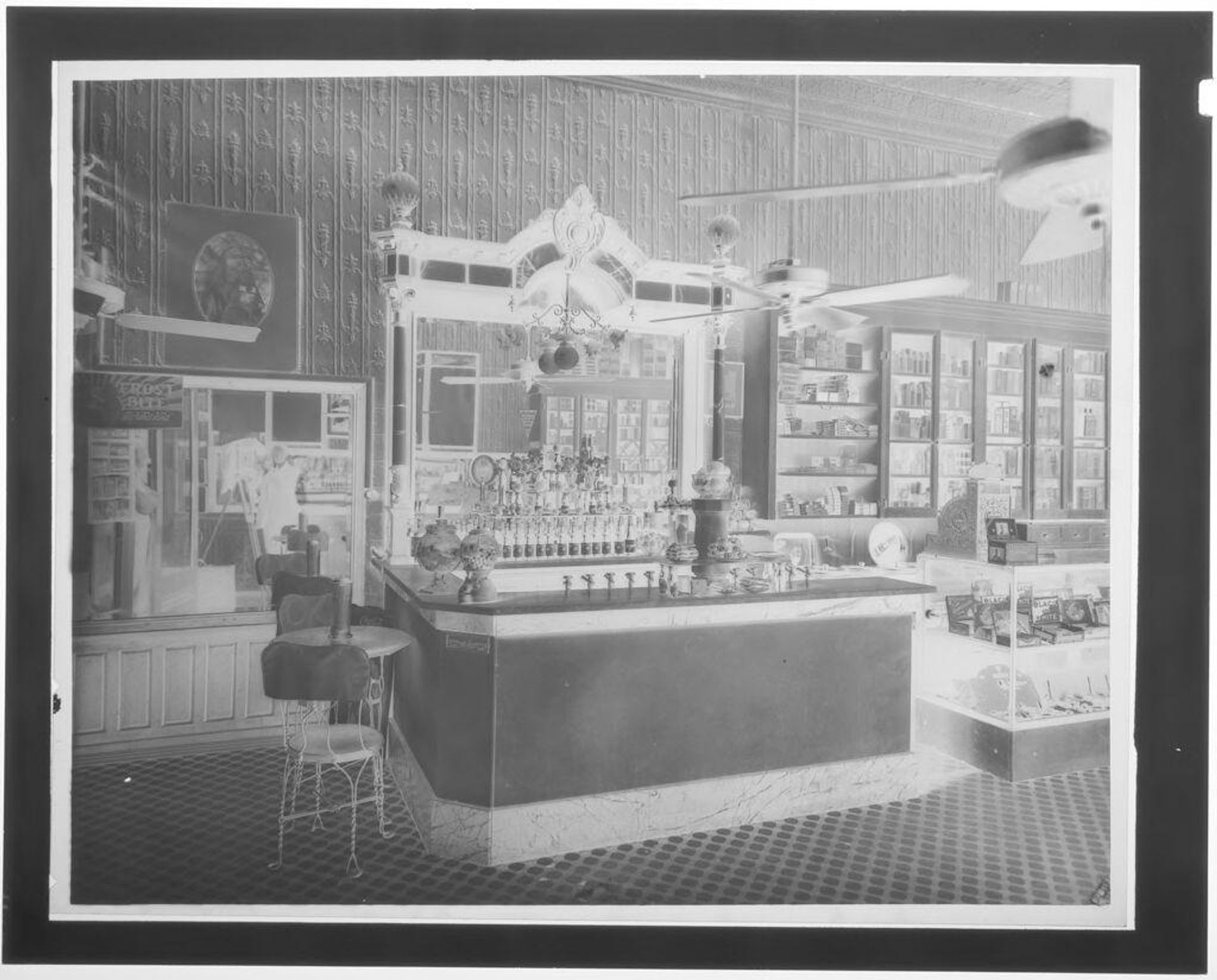 Untitled (drugstore interior with reflection of photographer in mirror) by Hamblin Studio