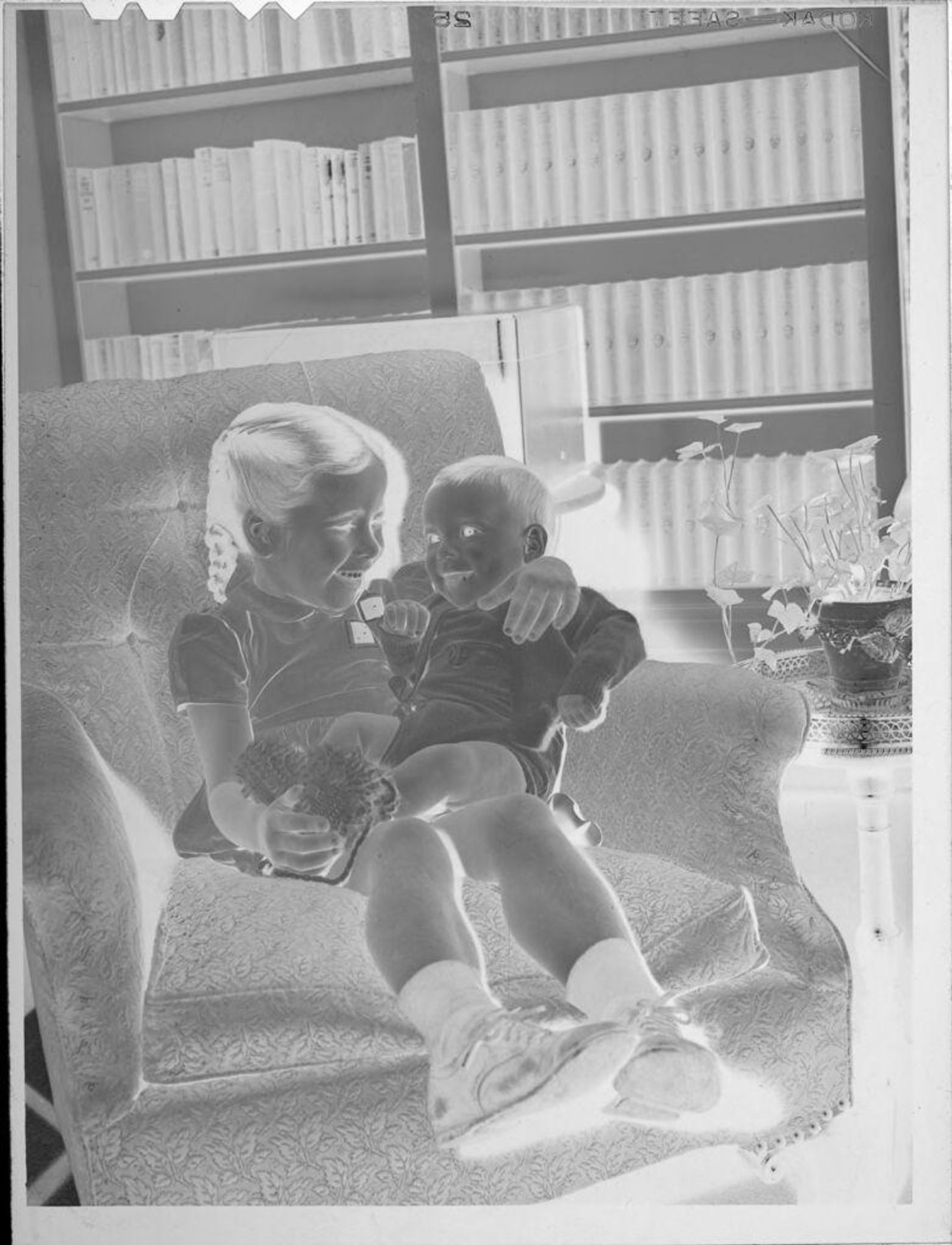 Untitled (girl holding baby on chair) by Lucian and Mary Brown
