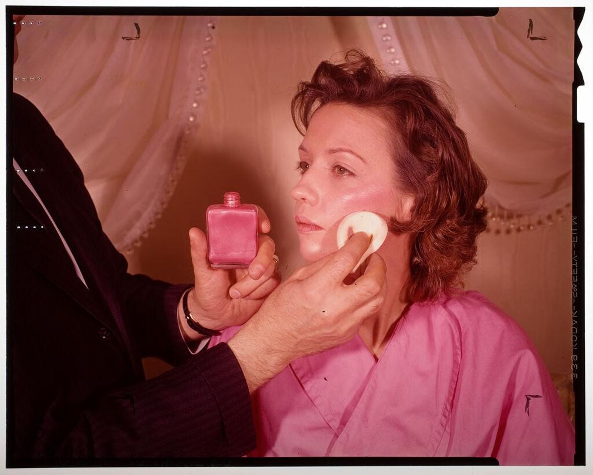 Untitled (man applying blush to woman's cheeks) by Jack Gould