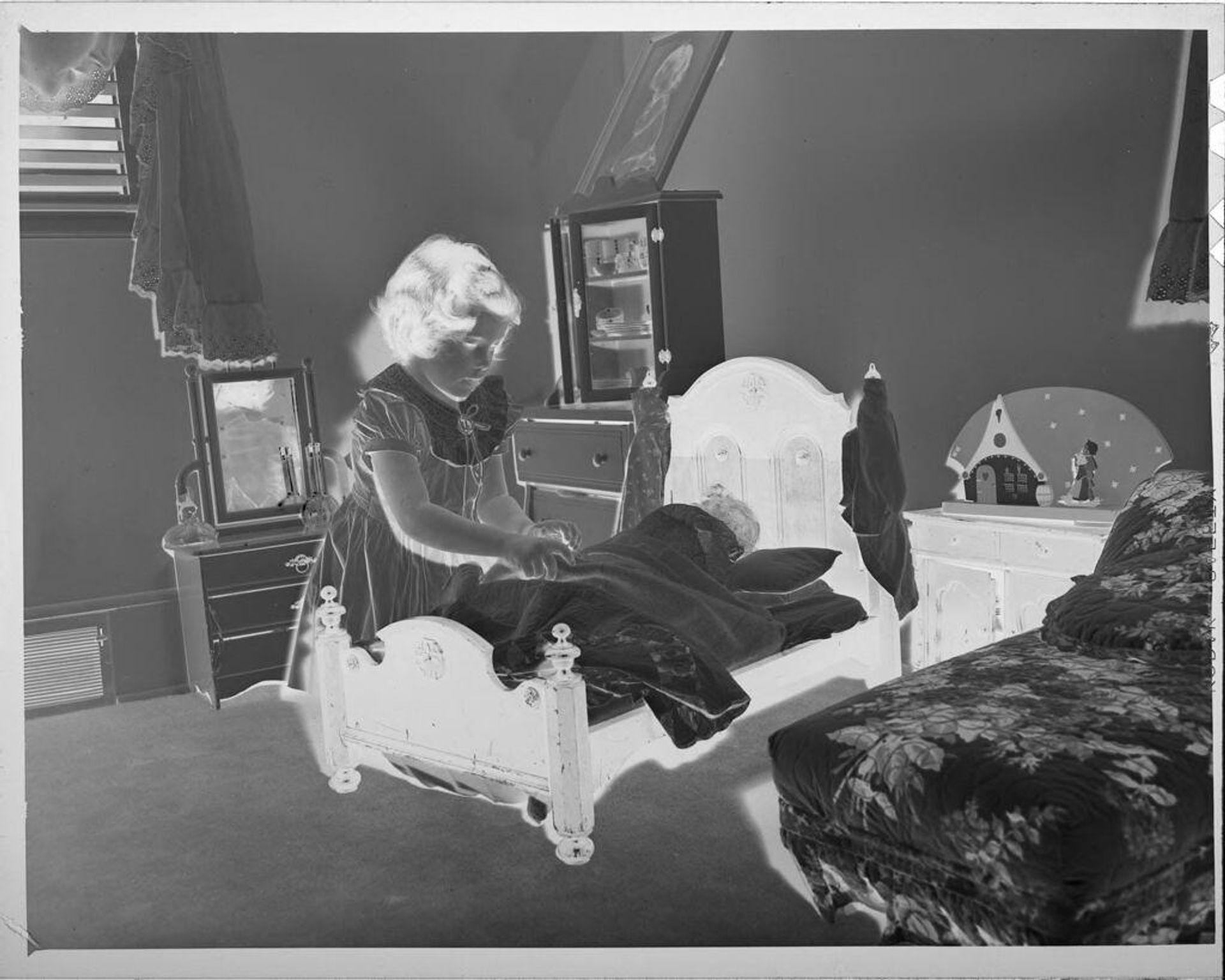 Untitled (girl with doll in toy bed) by Lucian and Mary Brown