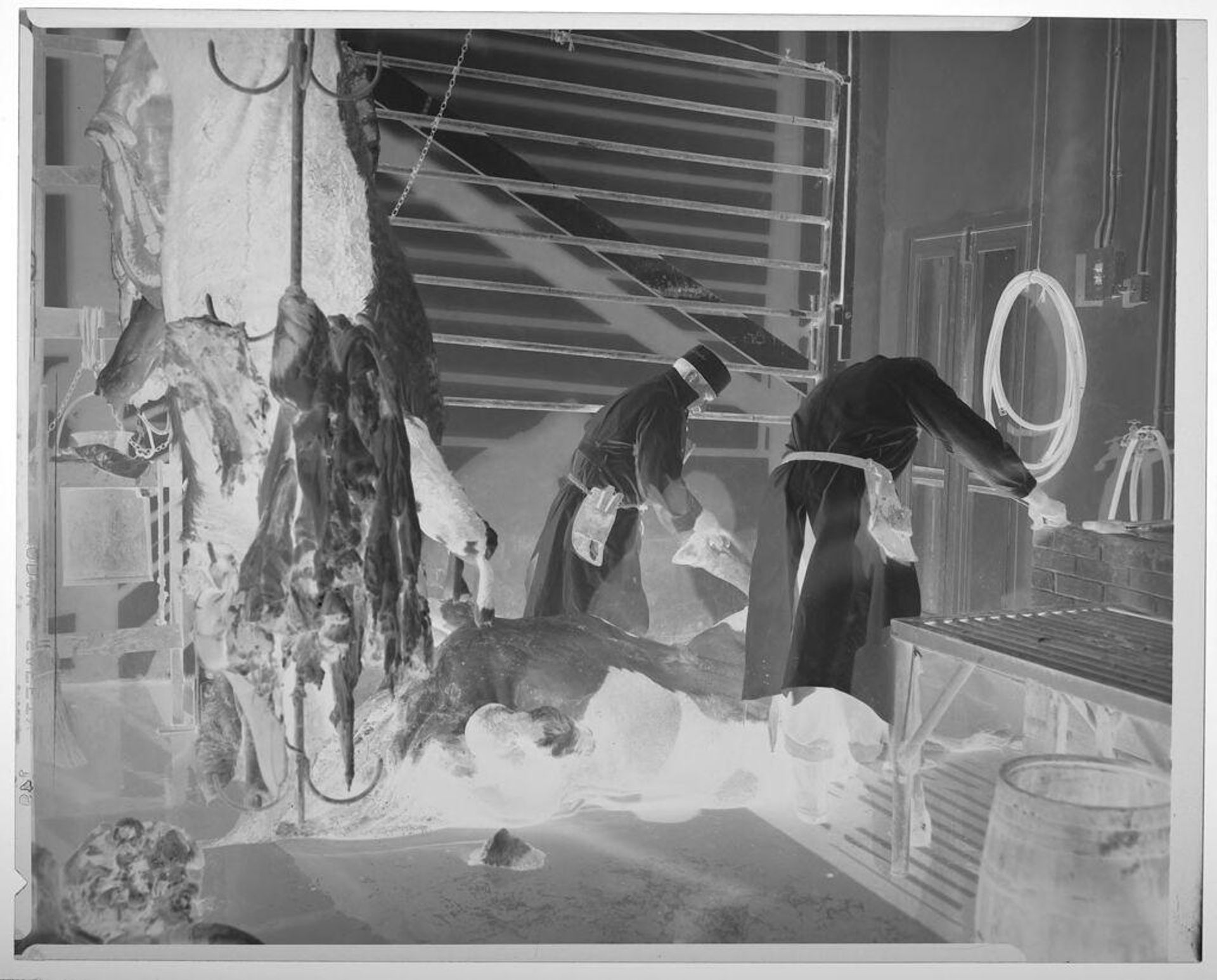 Untitled (men working with carcasses in Kreuz met market) by Harry Annas