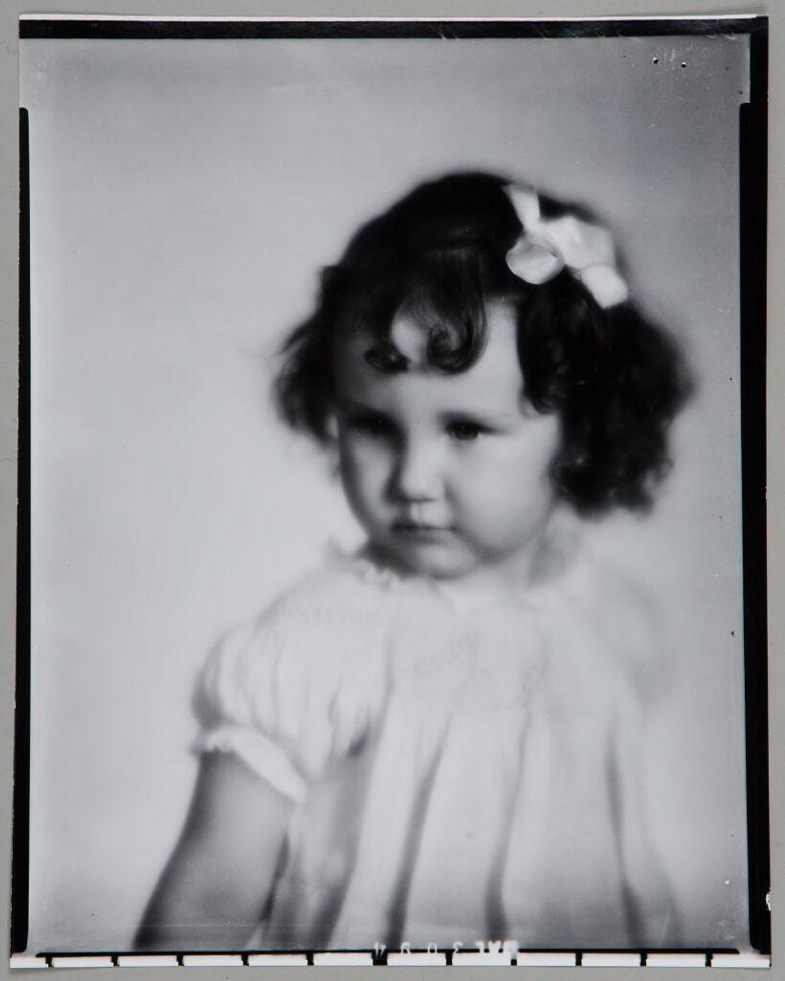 Untitled (portrait of little girl with bow in curly hair) by Paul Gittings