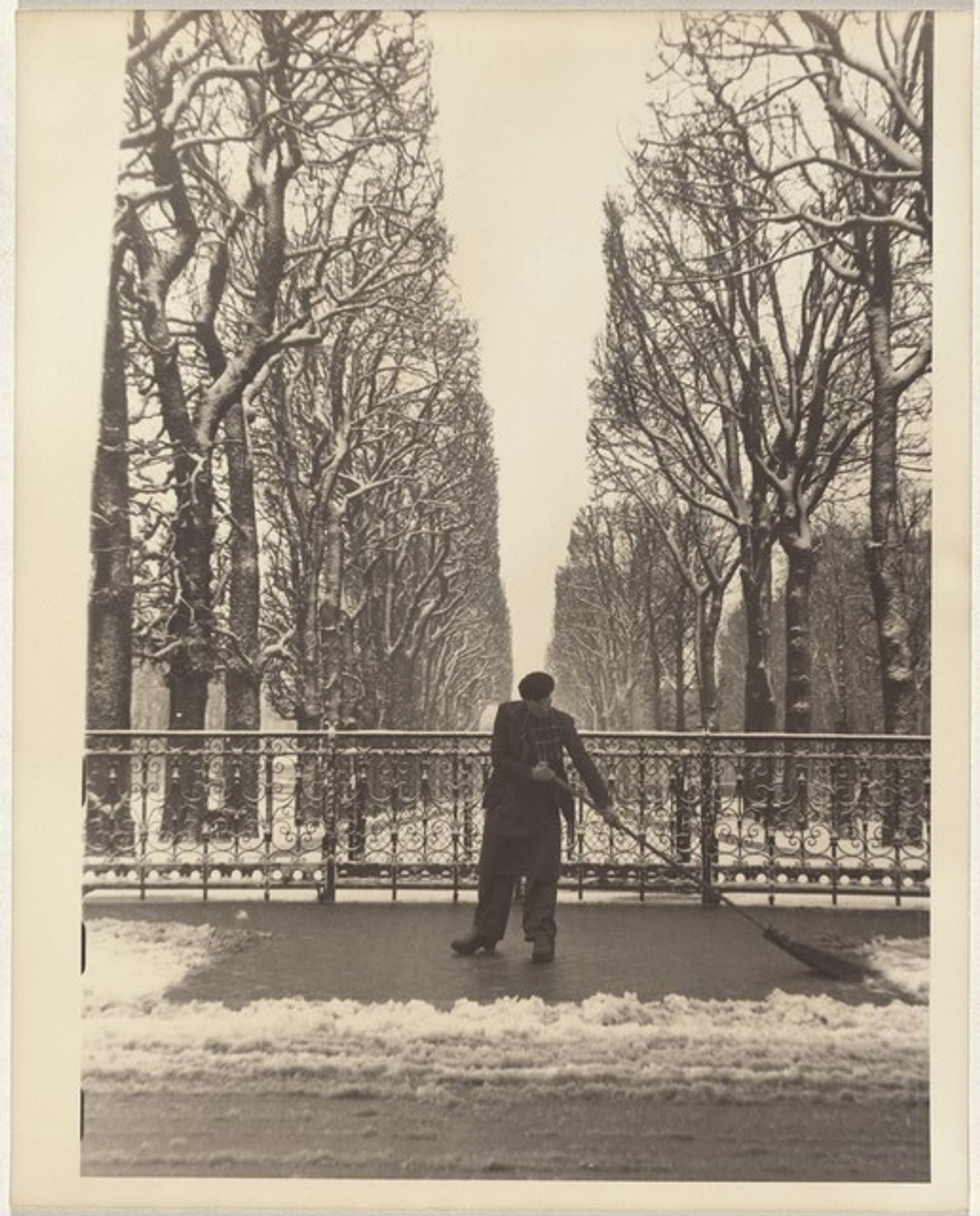 Man sweeping snow from sidewalk, Paris by Robert Frank