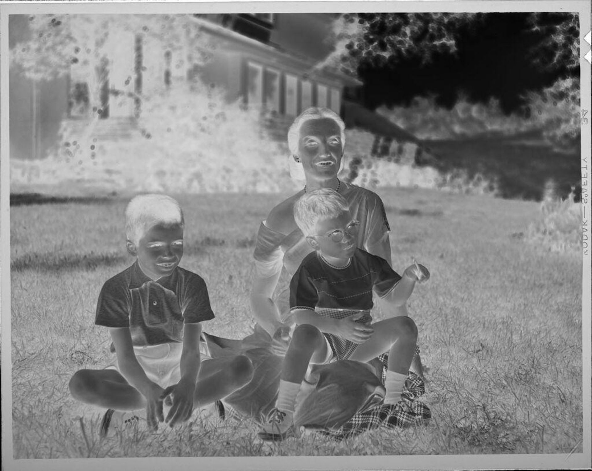 Untitled (woman and two children on lawn in front of house) by Lucian and Mary Brown