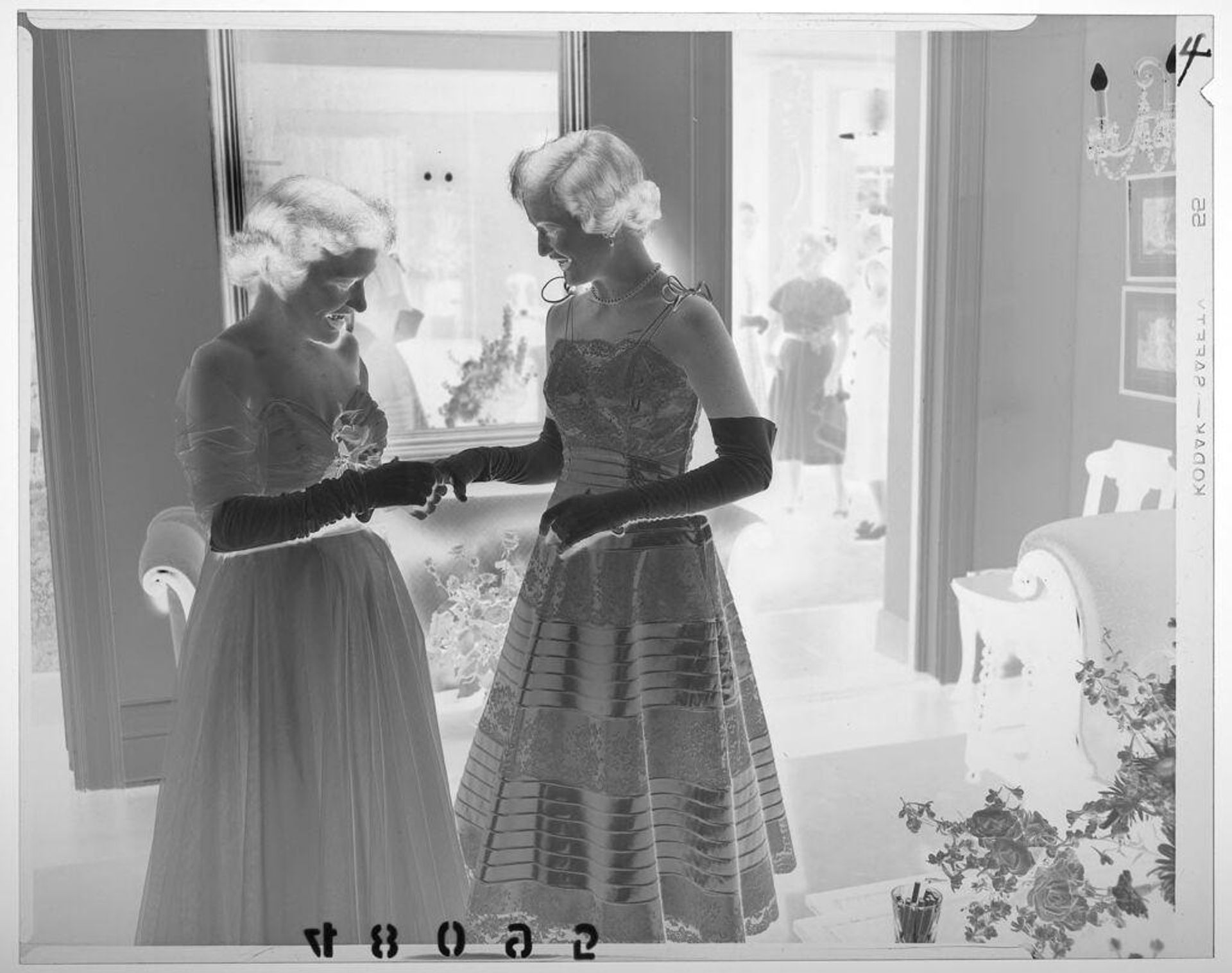 Untitled (woman examining another woman's glove at party) by Martin Schweig