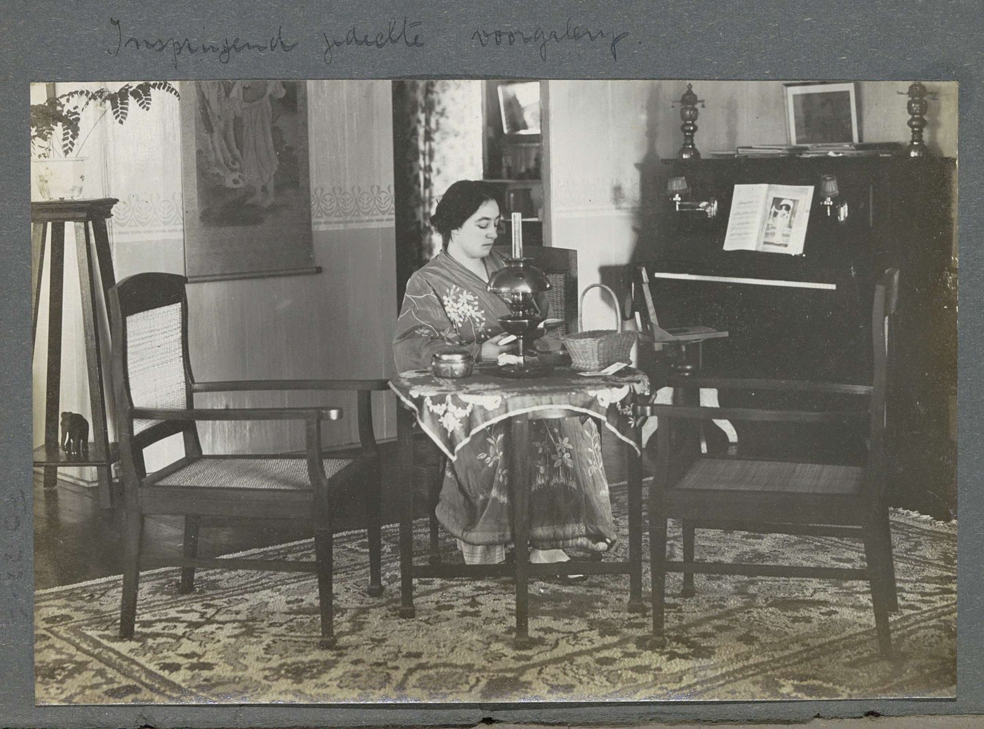 Gerda Bergsma in lang gewaad zittend aan tafel in een woonhuis op Sumatra by Anonymous