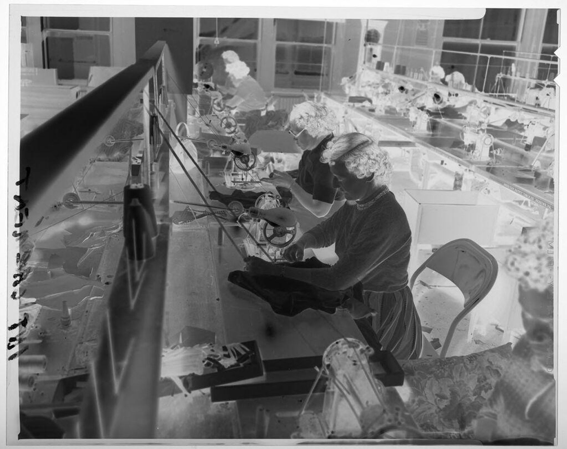 Untitled (line of women working on sewing machines in warehouse room) by Martin Schweig
