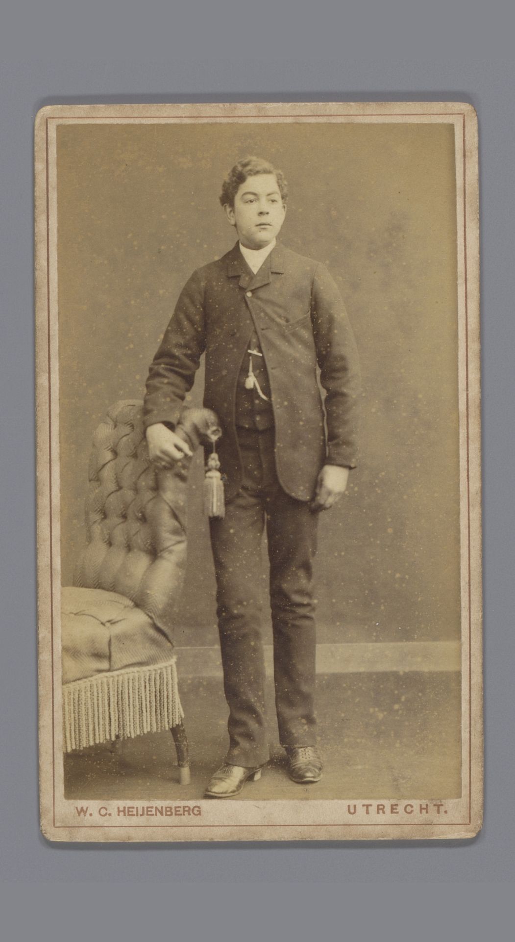 Portret van een onbekende man, staande naast een stoel by Willem Carel Heijenberg