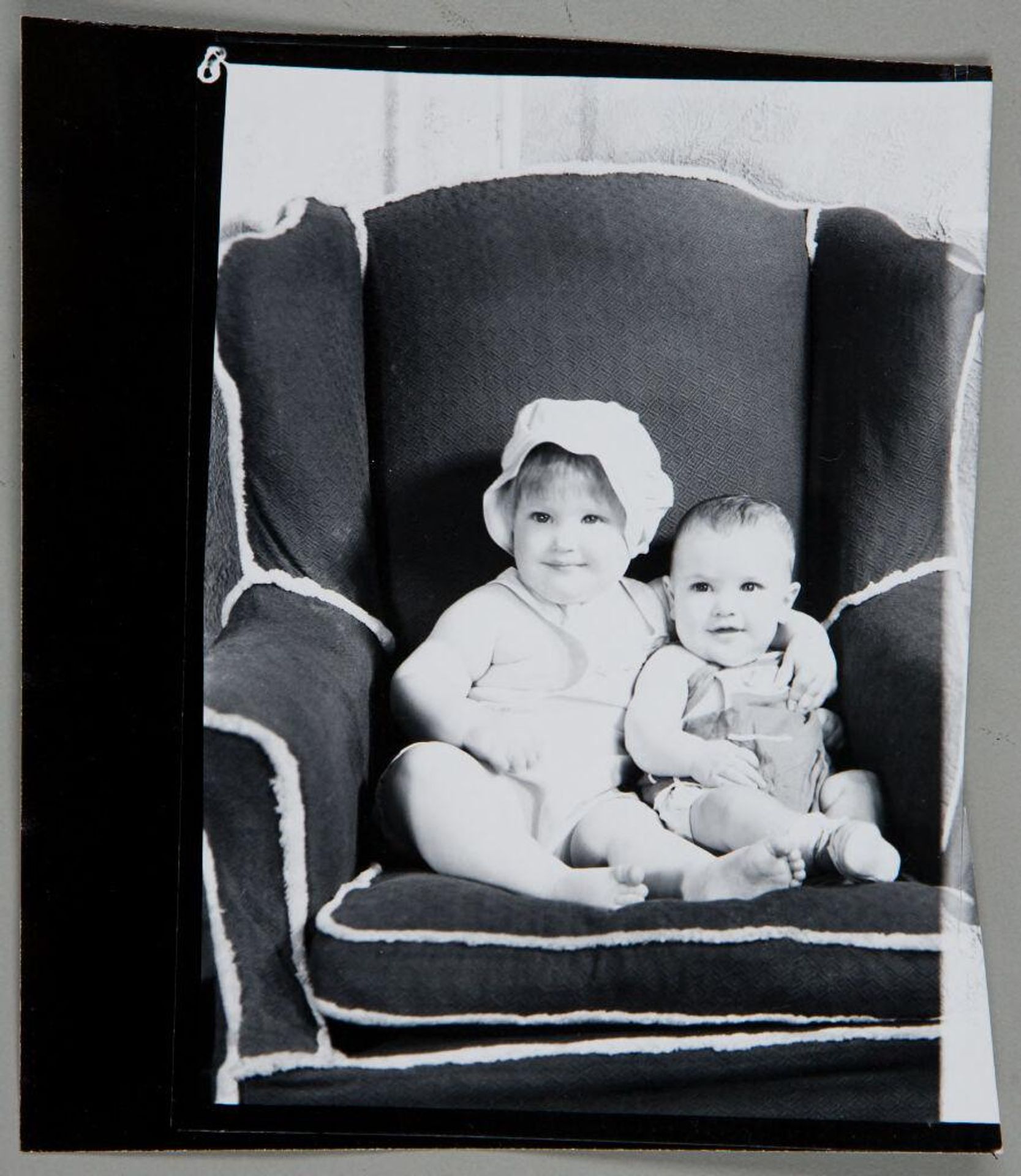 Untitled (baby boy and baby girl posed sitting in large chair) by Martin Schweig