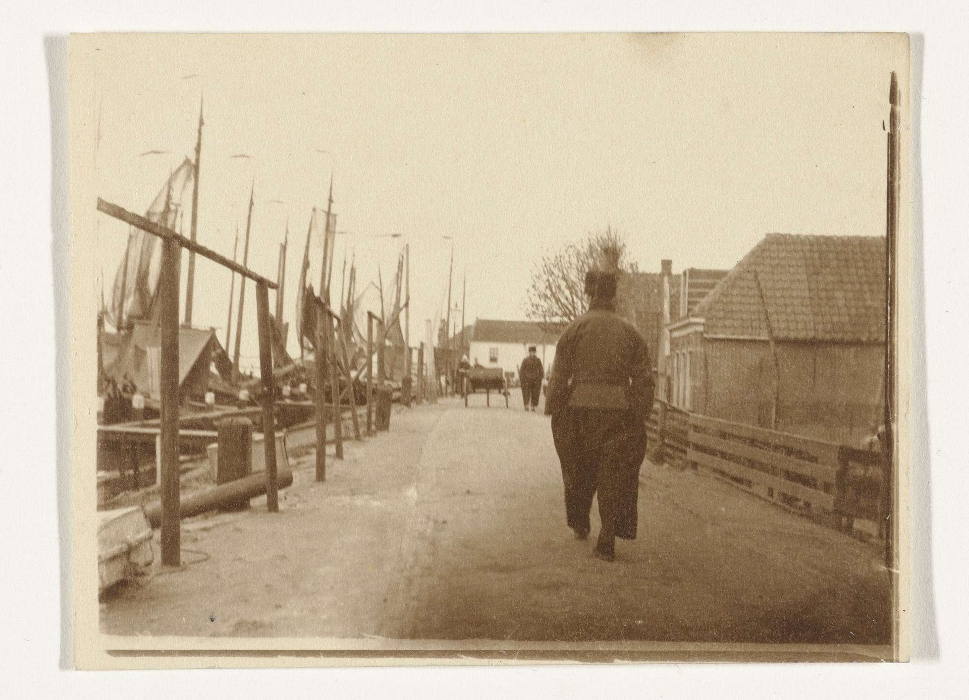 Mannen in klederdracht langs de haven in Volendam by G. Hidderley