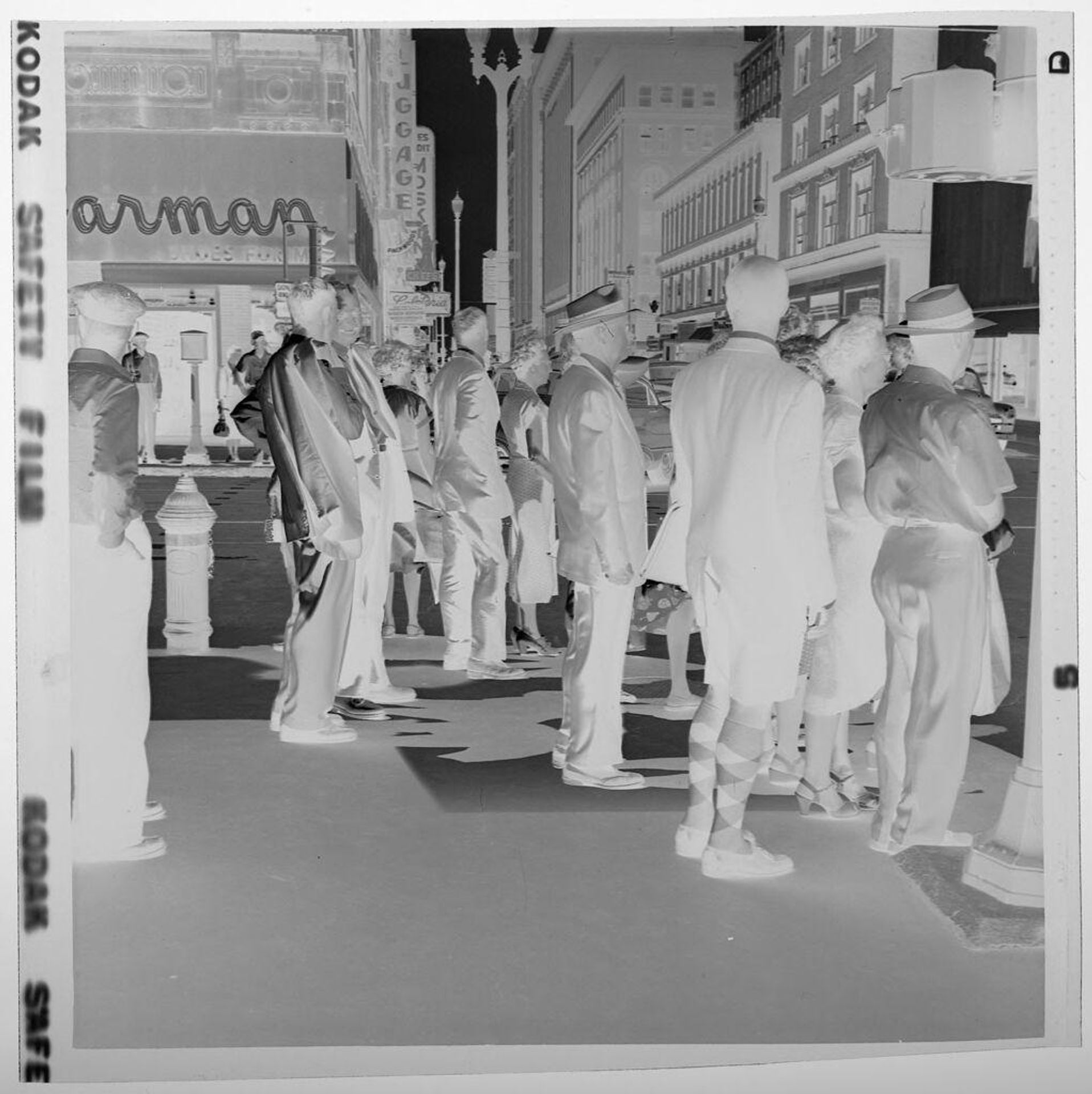Untitled (man wearing shorts and argyle socks among crowd of people on street) by Jack Gould