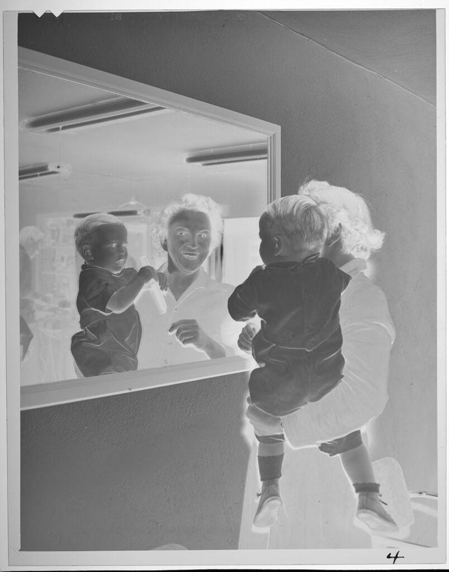 Untitled (woman holding baby, looking into mirror) by Lucian and Mary Brown