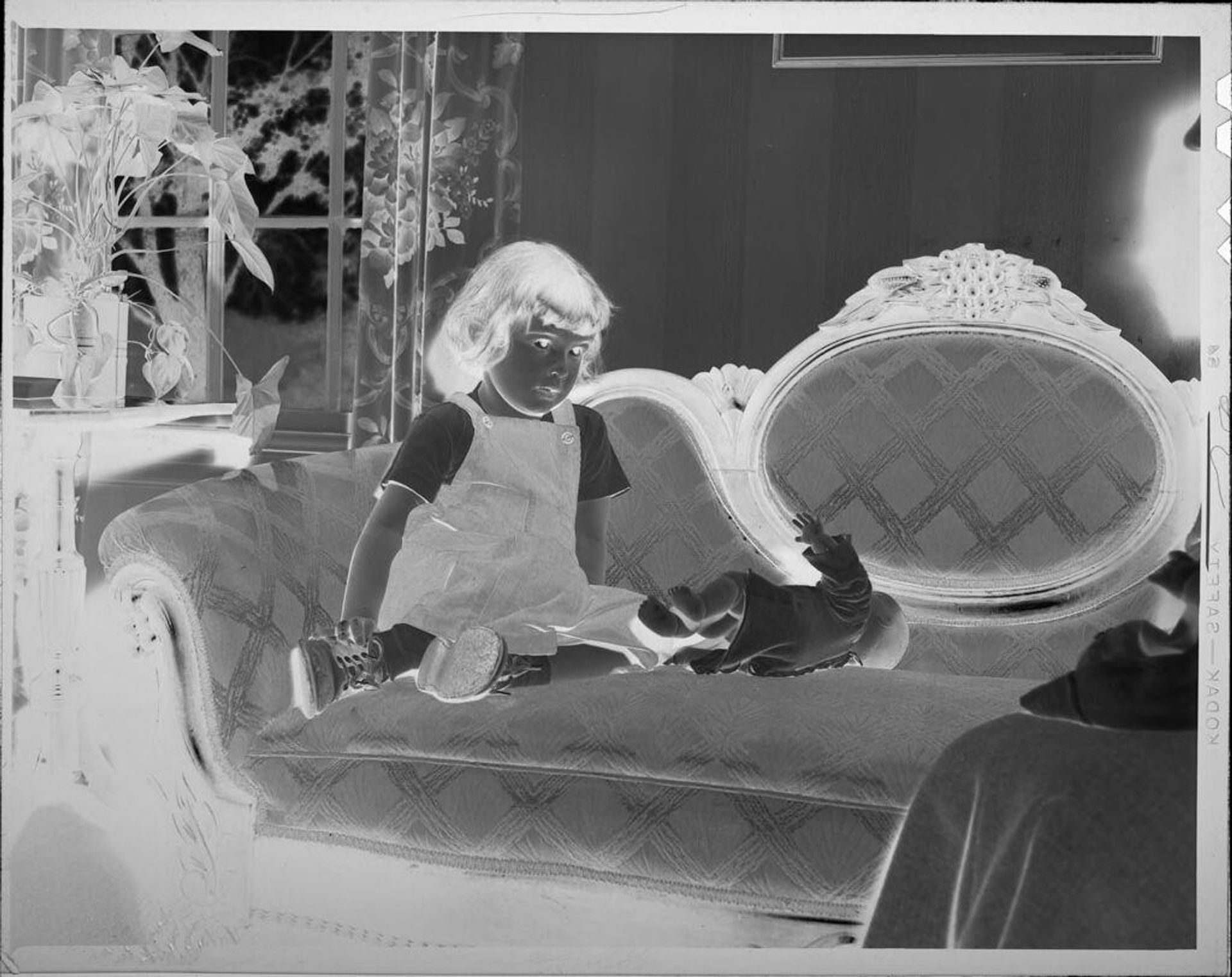 Untitled (girl on couch with doll) by Lucian and Mary Brown