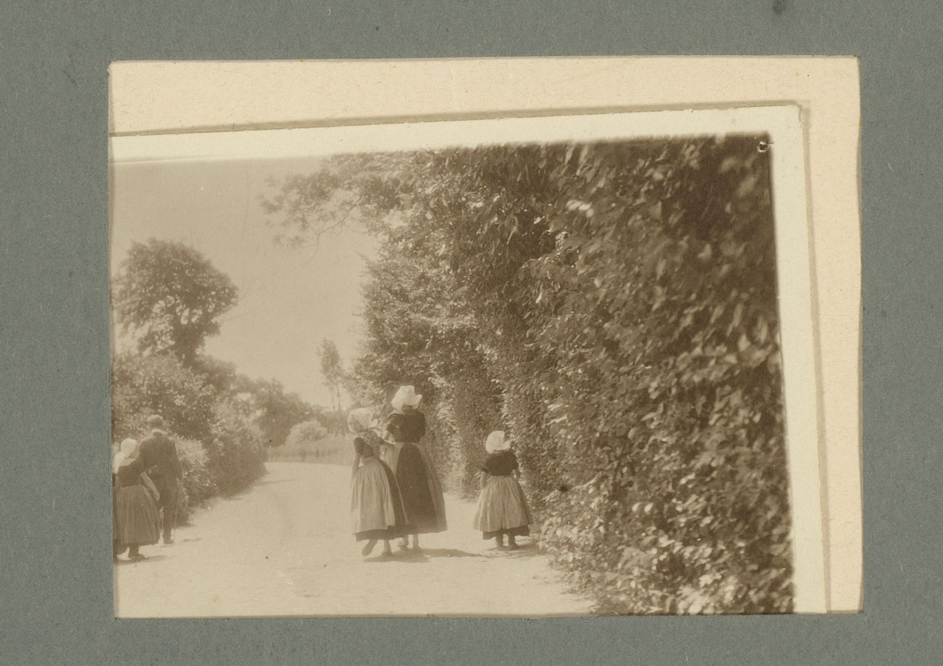Gezin in klederdracht, op de rug gezien by G. Hidderley