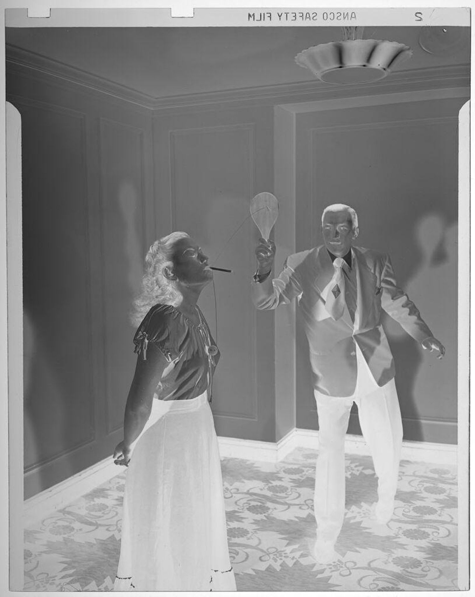 Untitled (man and woman playing with paddle ball) by Jack Gould