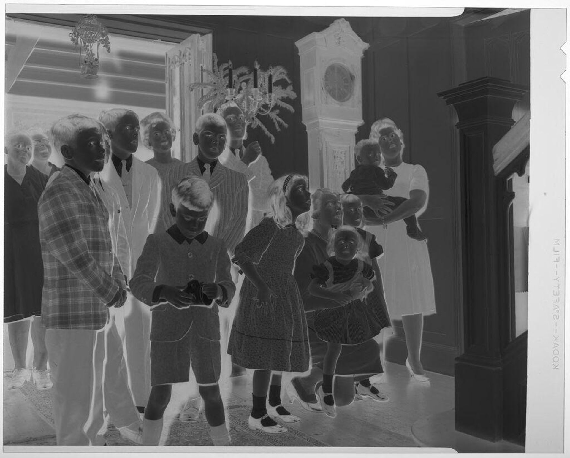 Untitled (children and adults gathered at bottom of staircase while looking up) by Martin Schweig