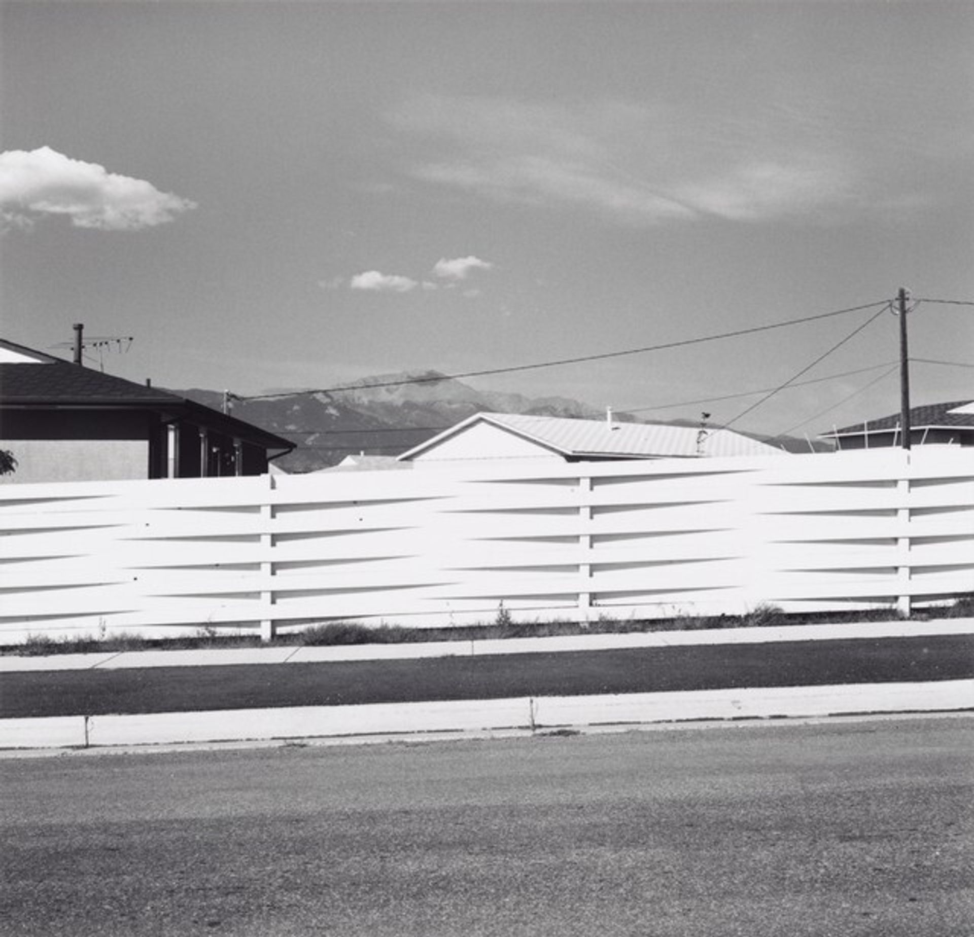 Pikes Peak, over the top of a fence, and new houses, Colorado Springs, Colorado by Robert Adams