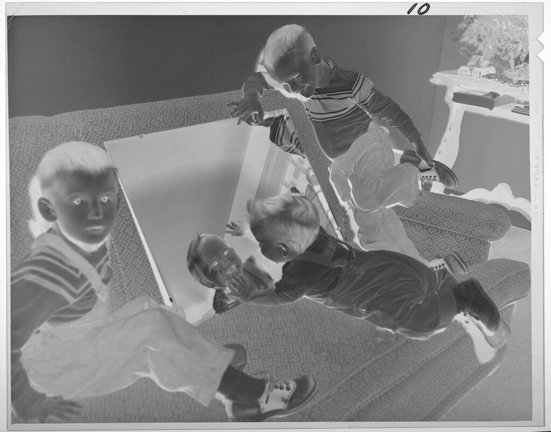 Untitled (boys playing on couch, baby looking into mirror) by Lucian and Mary Brown
