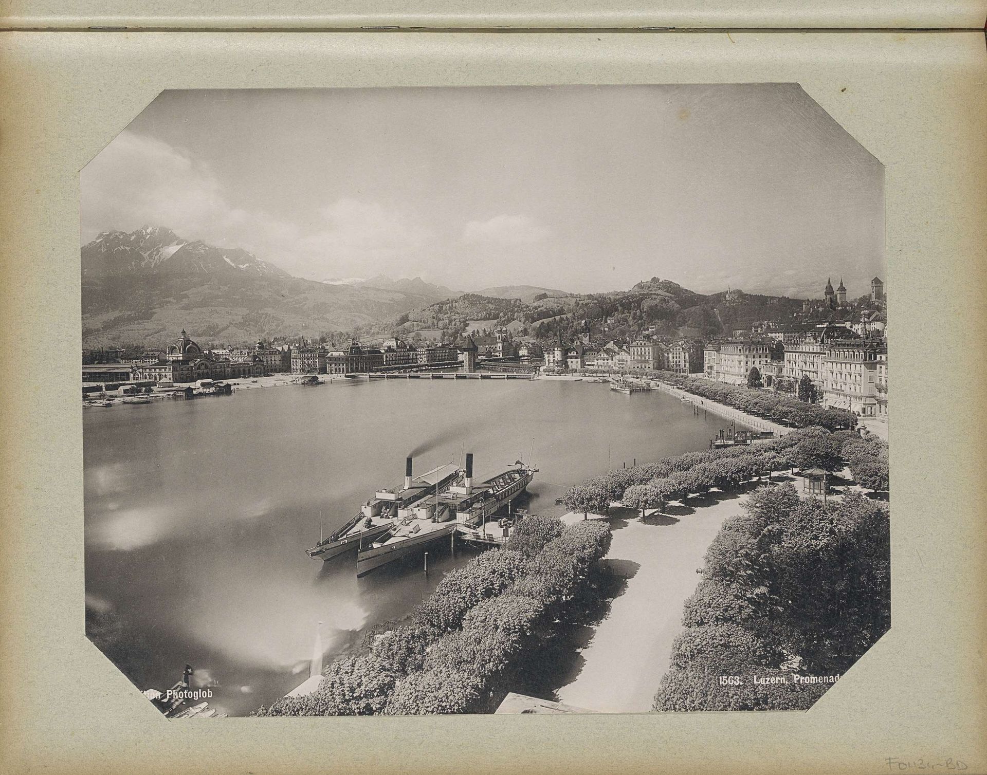Gezicht op Luzern met vooraan de promenade en aangemeerde boten en linksachter het spoorwegstation by Photoglob & Co.
