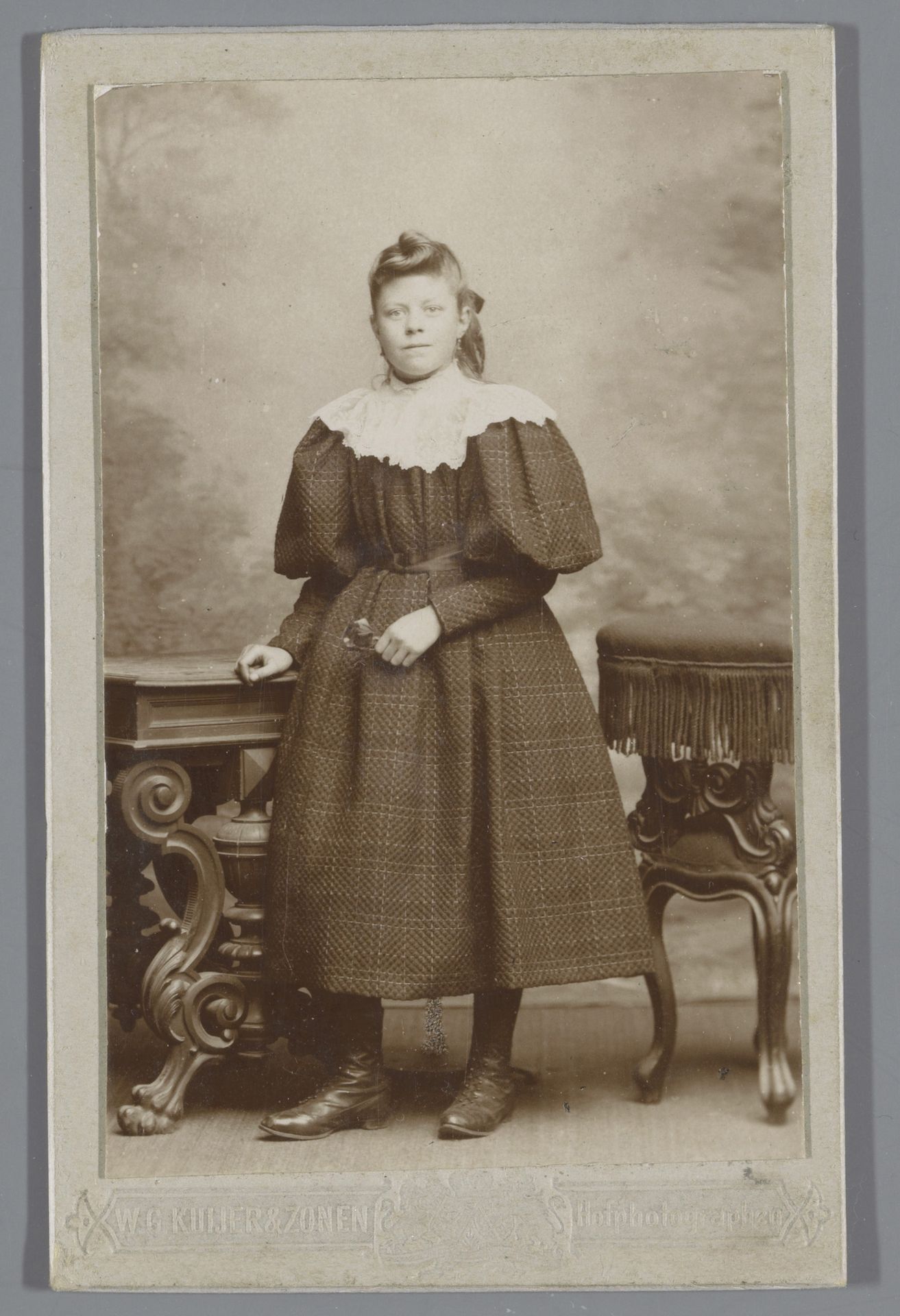 Portret van een onbekend meisje bij meubels by W.G. Kuijer & Zonen
