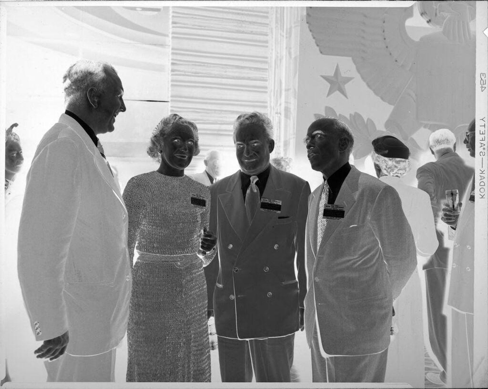 Untitled (three men and woman at party wearing nametags) by Peter James Studio