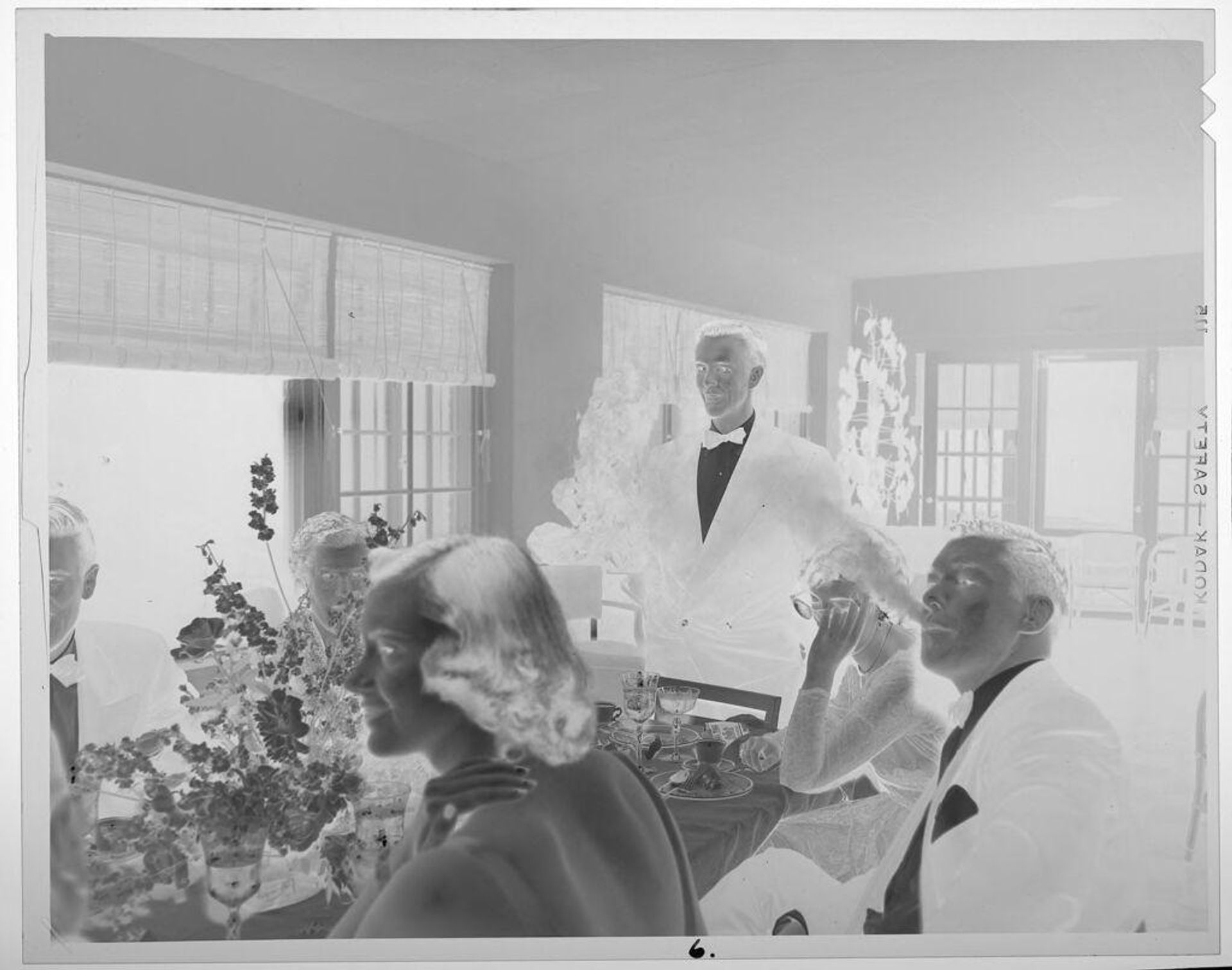 Untitled (man standing up at table during dinner party) by Lucian and Mary Brown