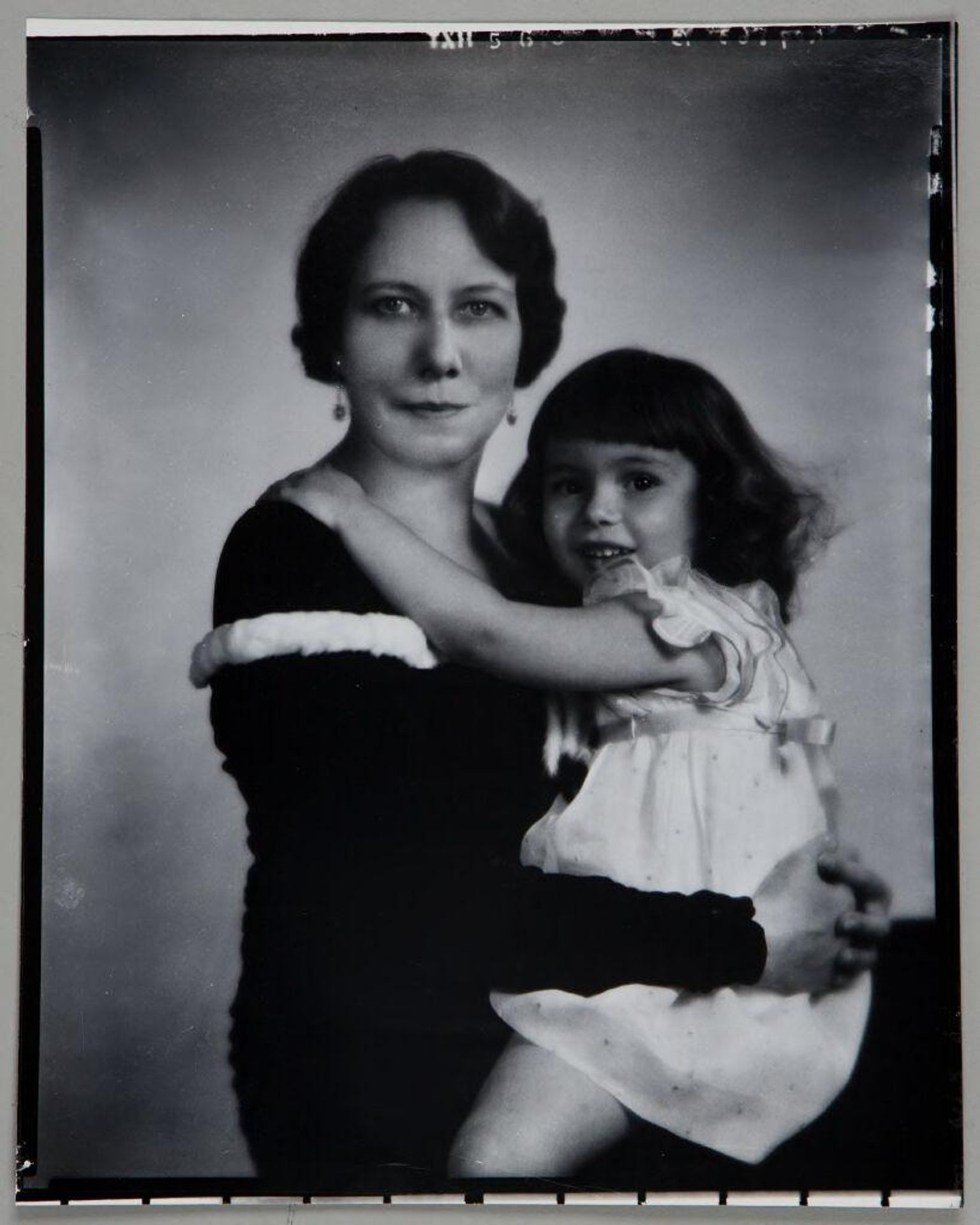 Untitled (portrait of mother seated with young daughter with arms around each other) by Paul Gittings