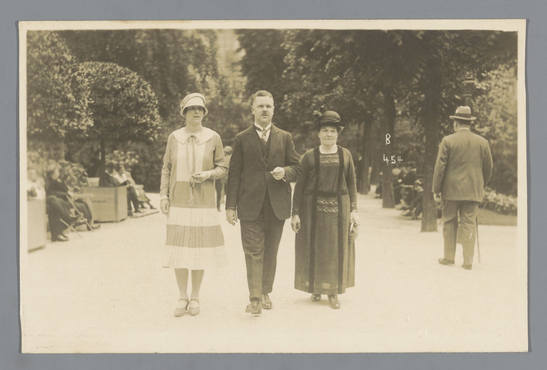 Portret van een onbekende man en twee vrouwen in een park by E.H. Hies