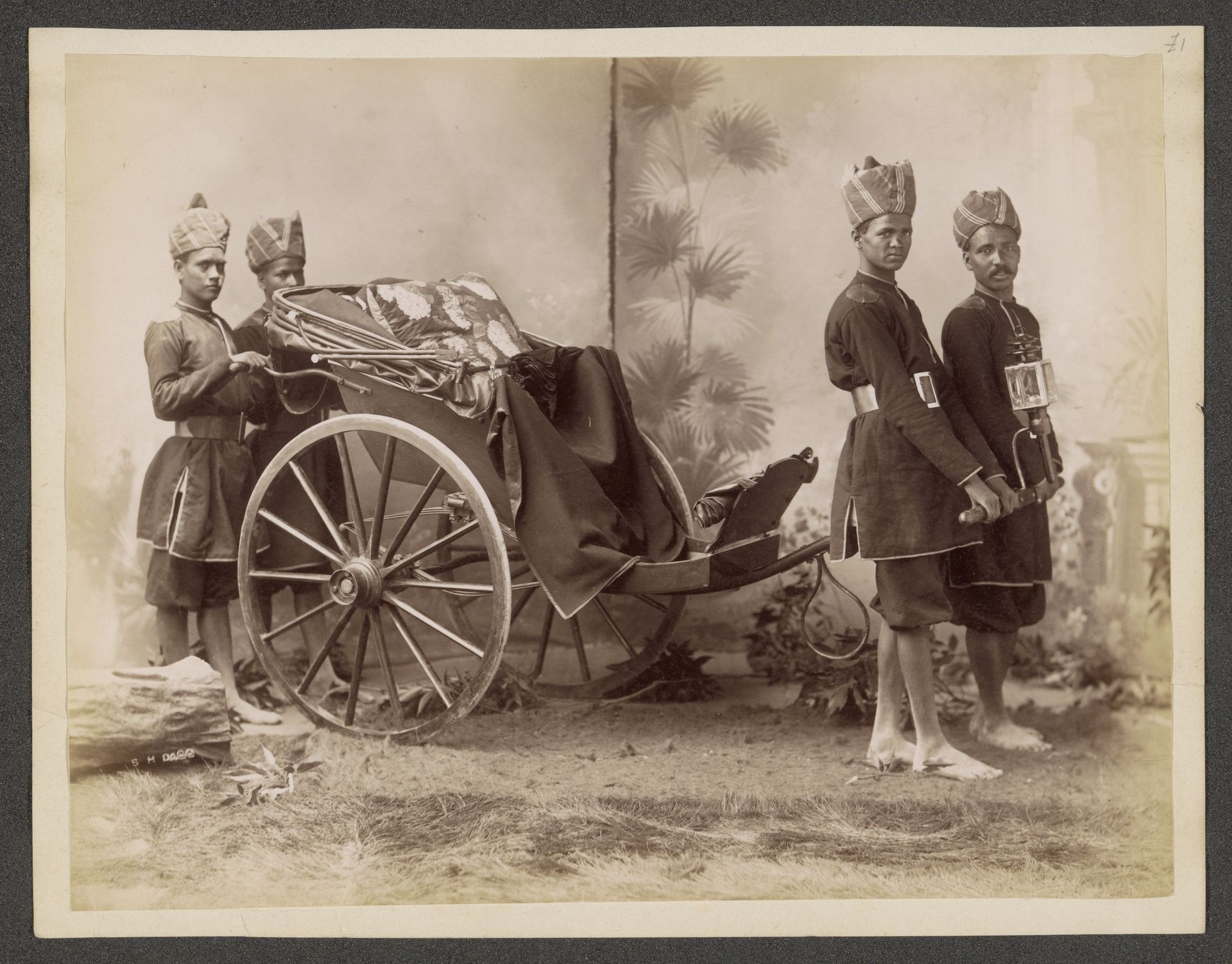 Studioportret van vier onbekende Indiase mannen in uniform met een rijtuig by Sidney Herbert Dagg