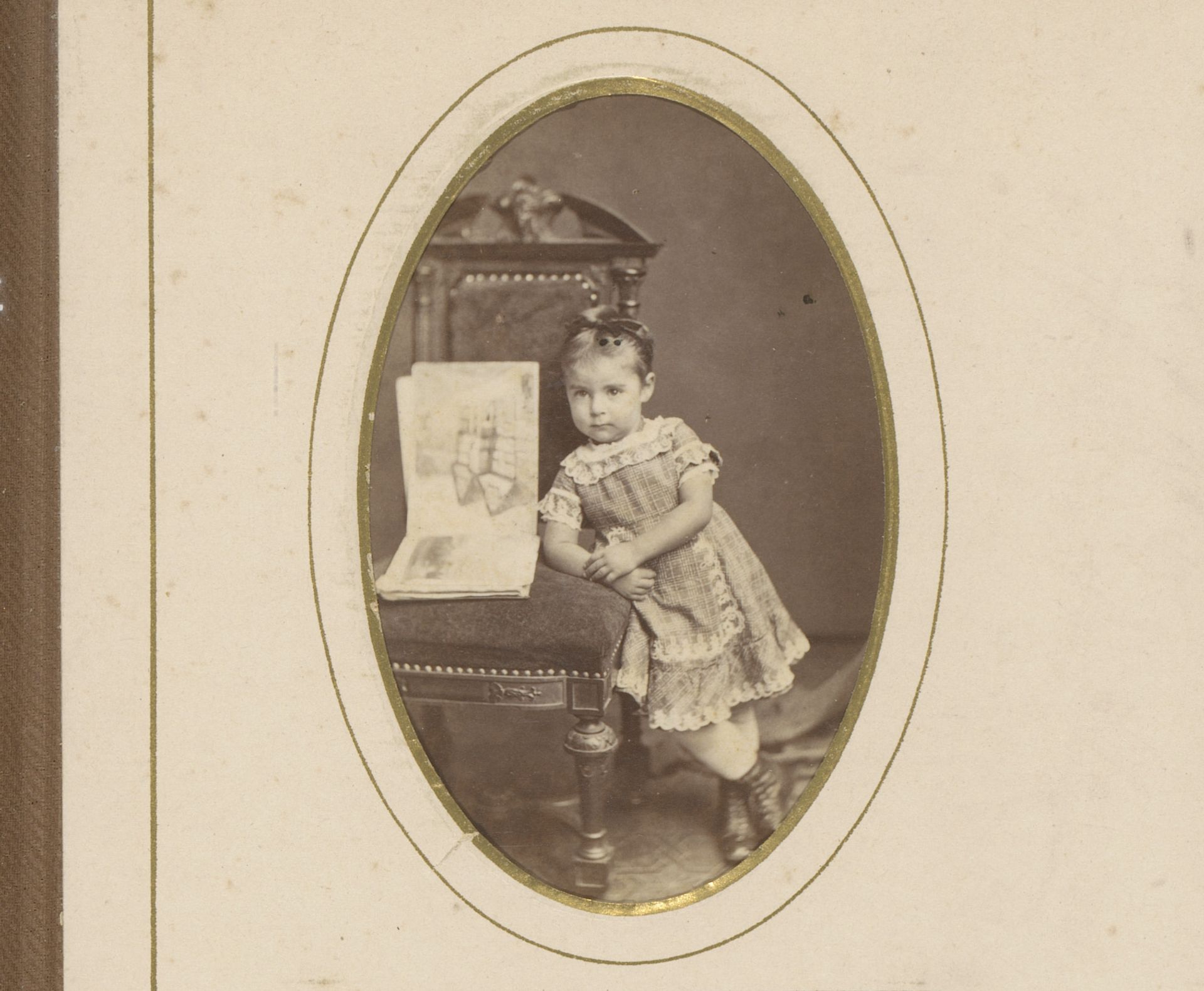Portret van een meisje bij een stoel met een open tekenboek by Albert Greiner